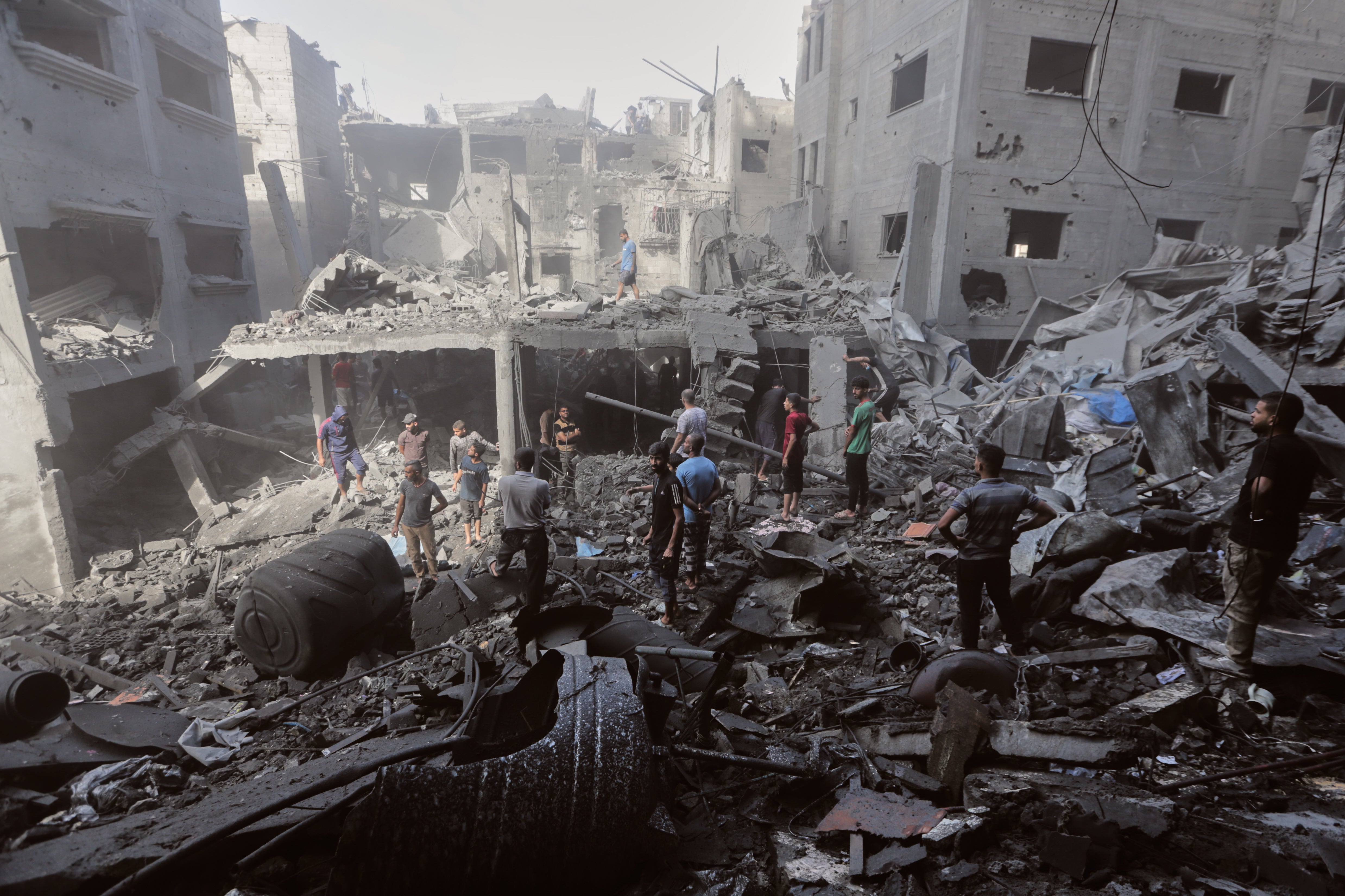 Palestinians inspect the rubble of a building destroyed by an Israeli army attack in al-Shati camp in Gaza City