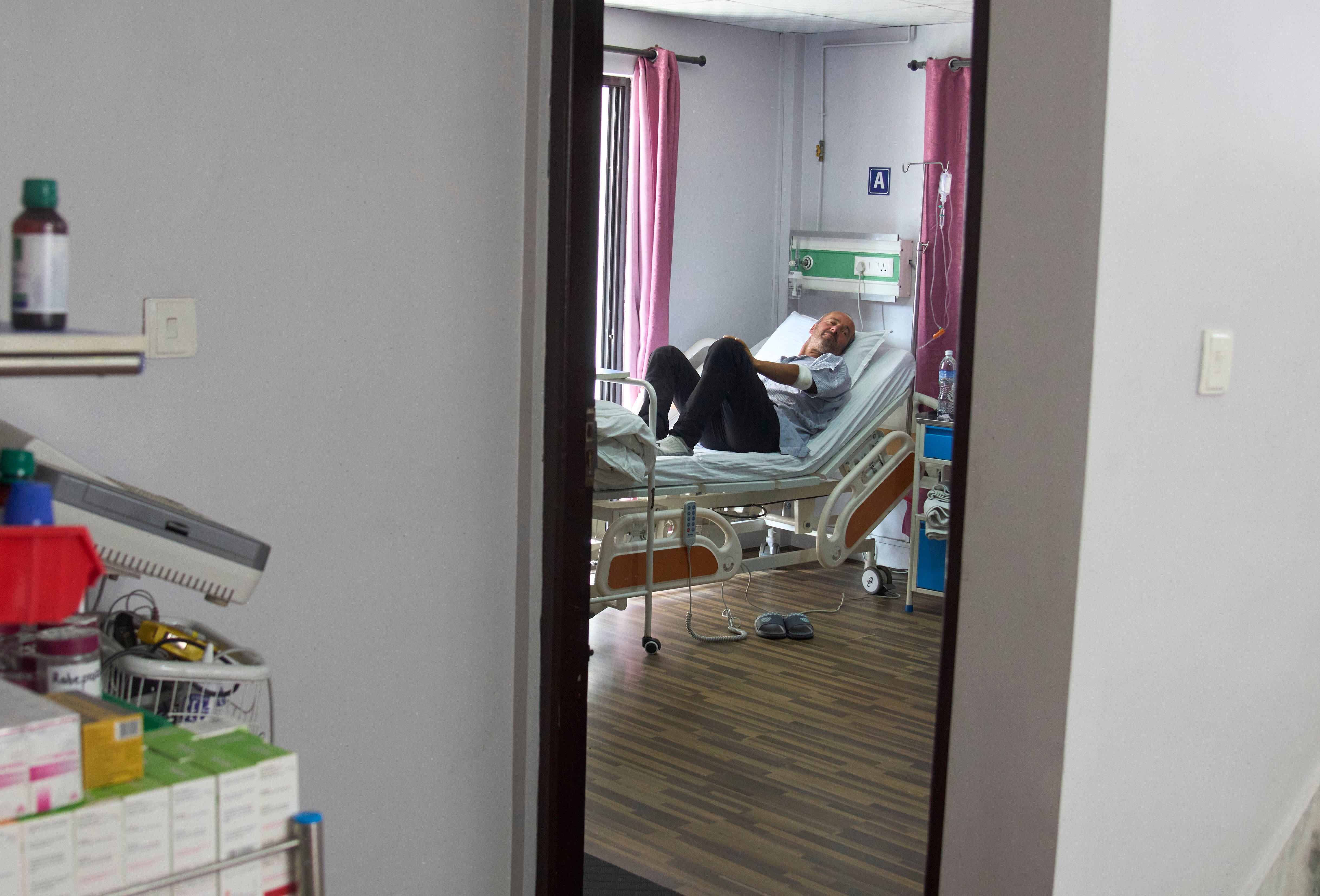 Didier Armand, a survivor of an avalanche on Mount Yalung Ri, takes rest after being rescued and airlifted to a hospital in Kathmandu, Nepal