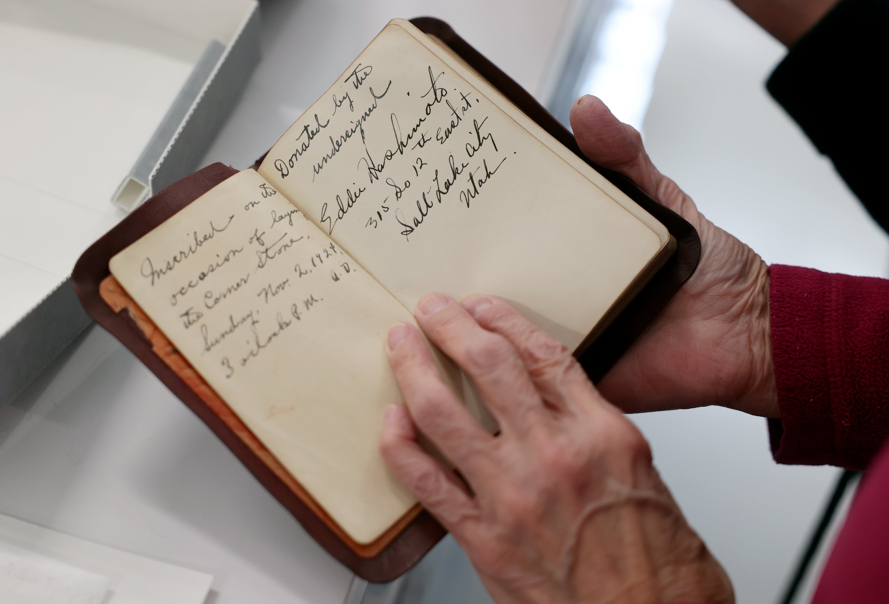 Joy Hashimoto Douglass holds a Bible donated in 1924 by her father, Eddie Hashimoto, and included in the contents of the Japanese Church of Christ's 100-year-old time capsule that was recently opened at the University of Utah Marriott Library Preservation Department