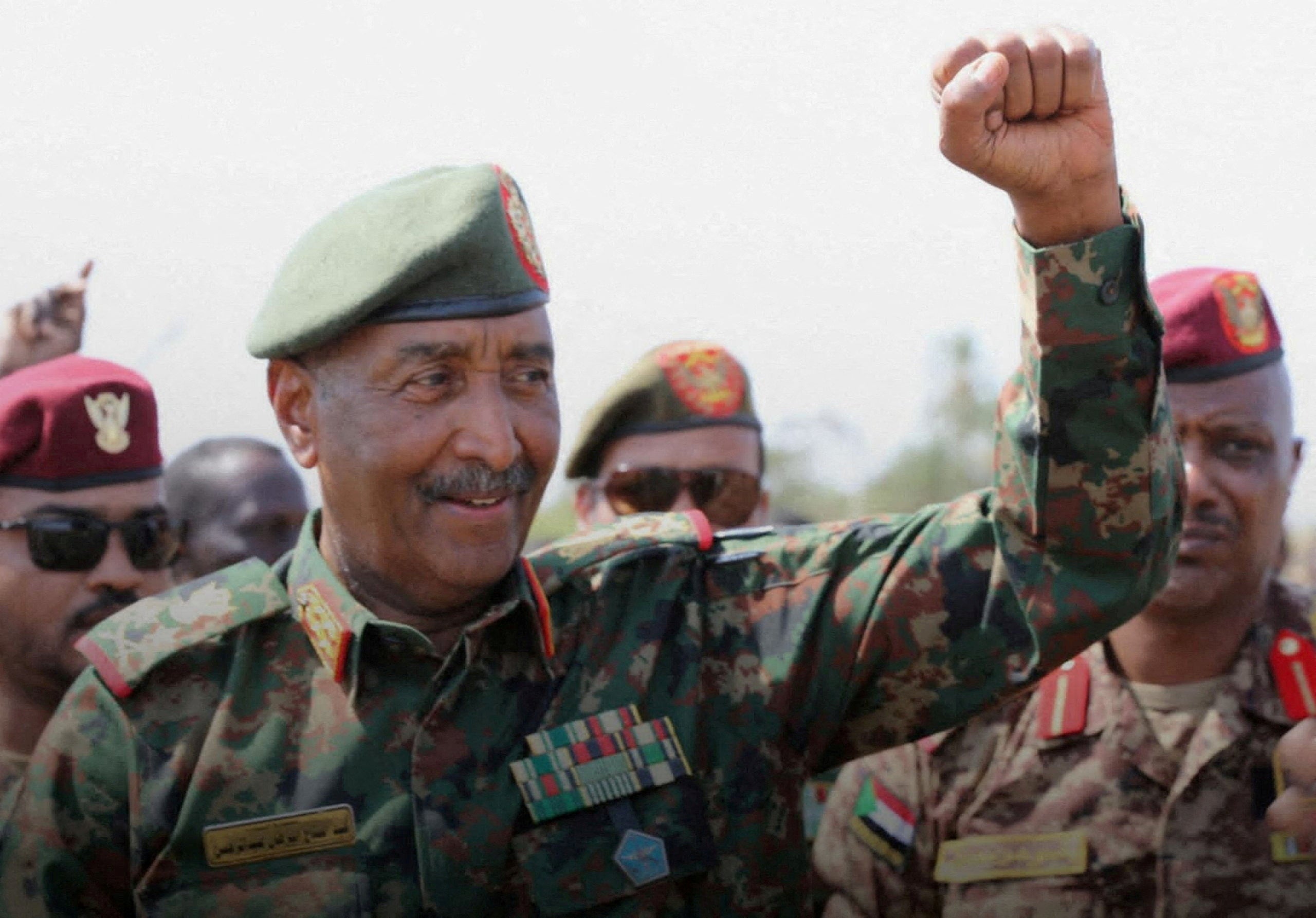 Sudan's army chief Abdel Fattah al-Burhan gestures to soldiers inside the presidential palace