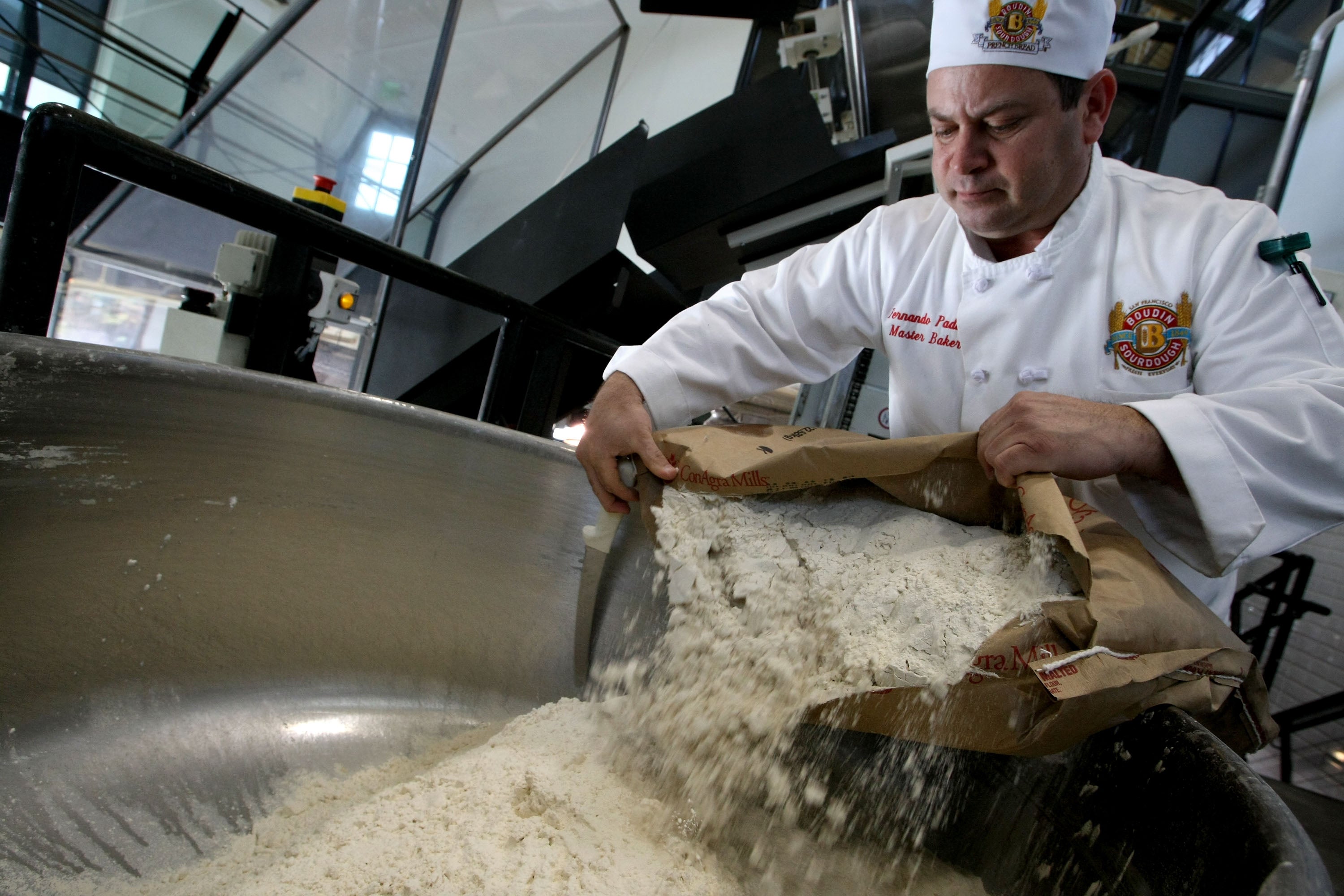 A baker pours a bag of flour into a mixer to make sourdough bread at Boudin Bakery in San Francisco, California, in April 2008. The special fermentation process of sourdough provides many of its health benefits.
