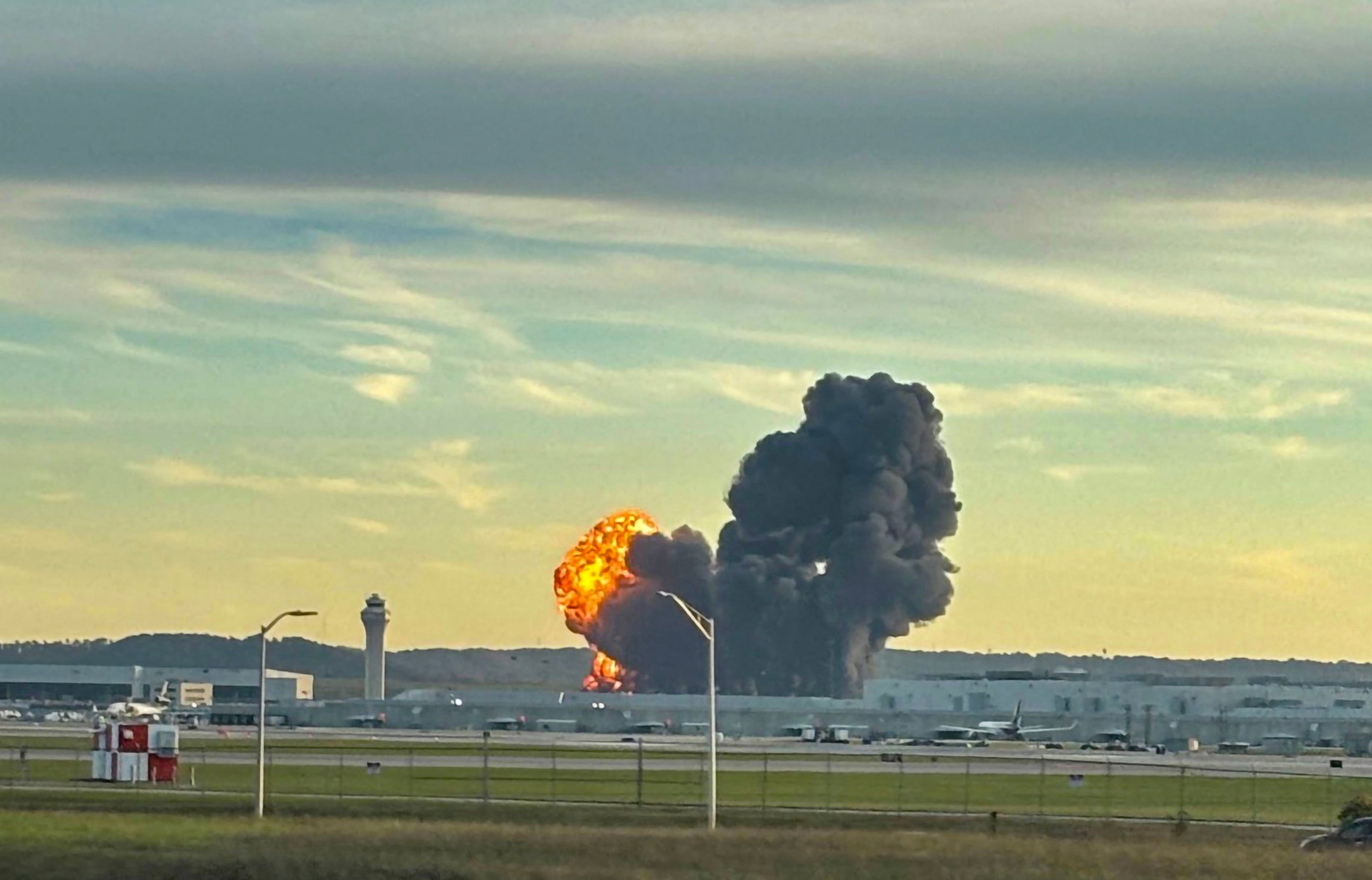A plume of smoke rises from Muhammad Ali International Airport after crash that officials described as “catastrophic”