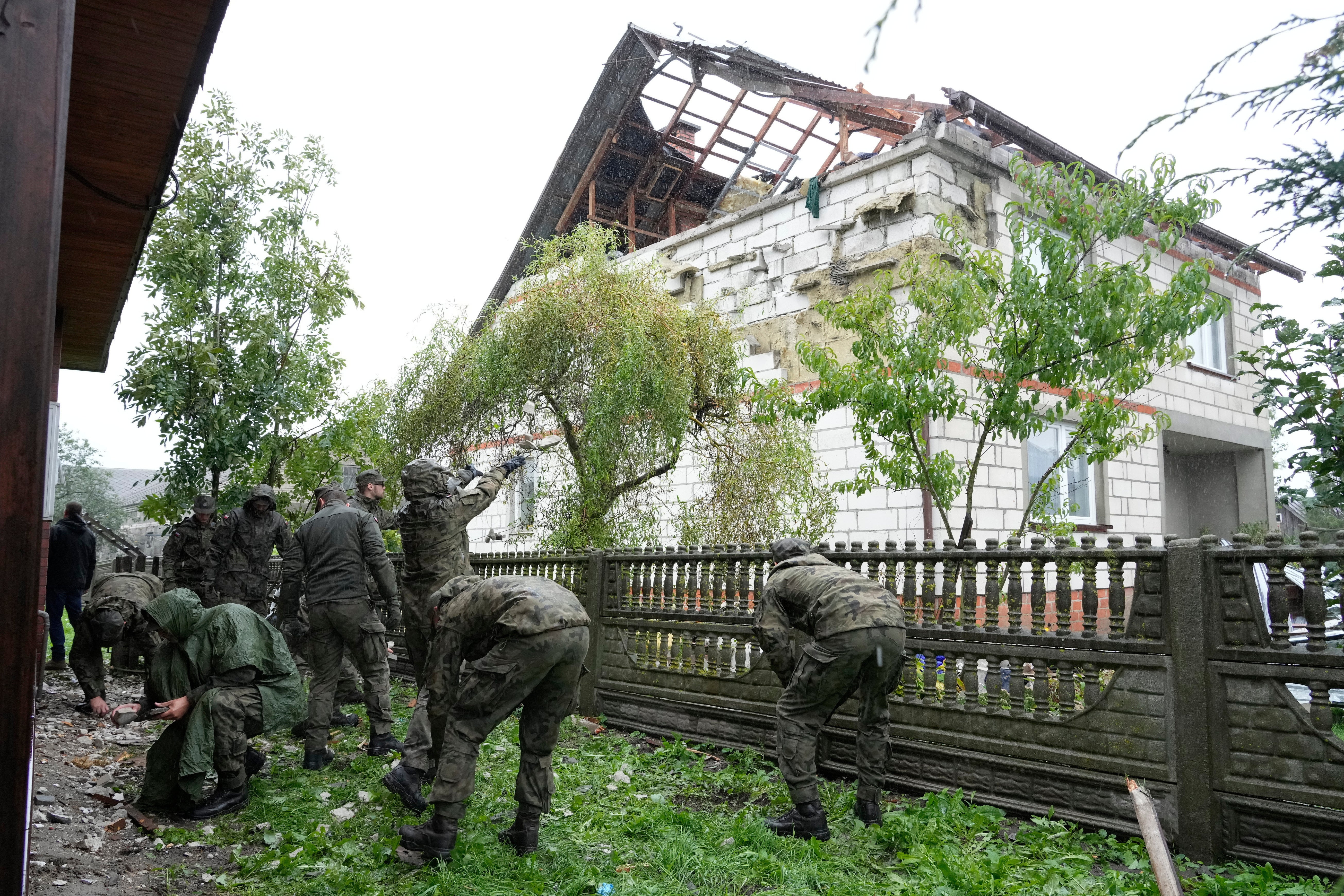 Territorial defense officers clean up debris from the destroyed roof of a house in Wyryki near Lublin, Poland, after Russian drones violated Polish airspace during an attack on Ukraine, on Sept. 11, 2025. (AP Photo/Czarek Sokolowski, File)
