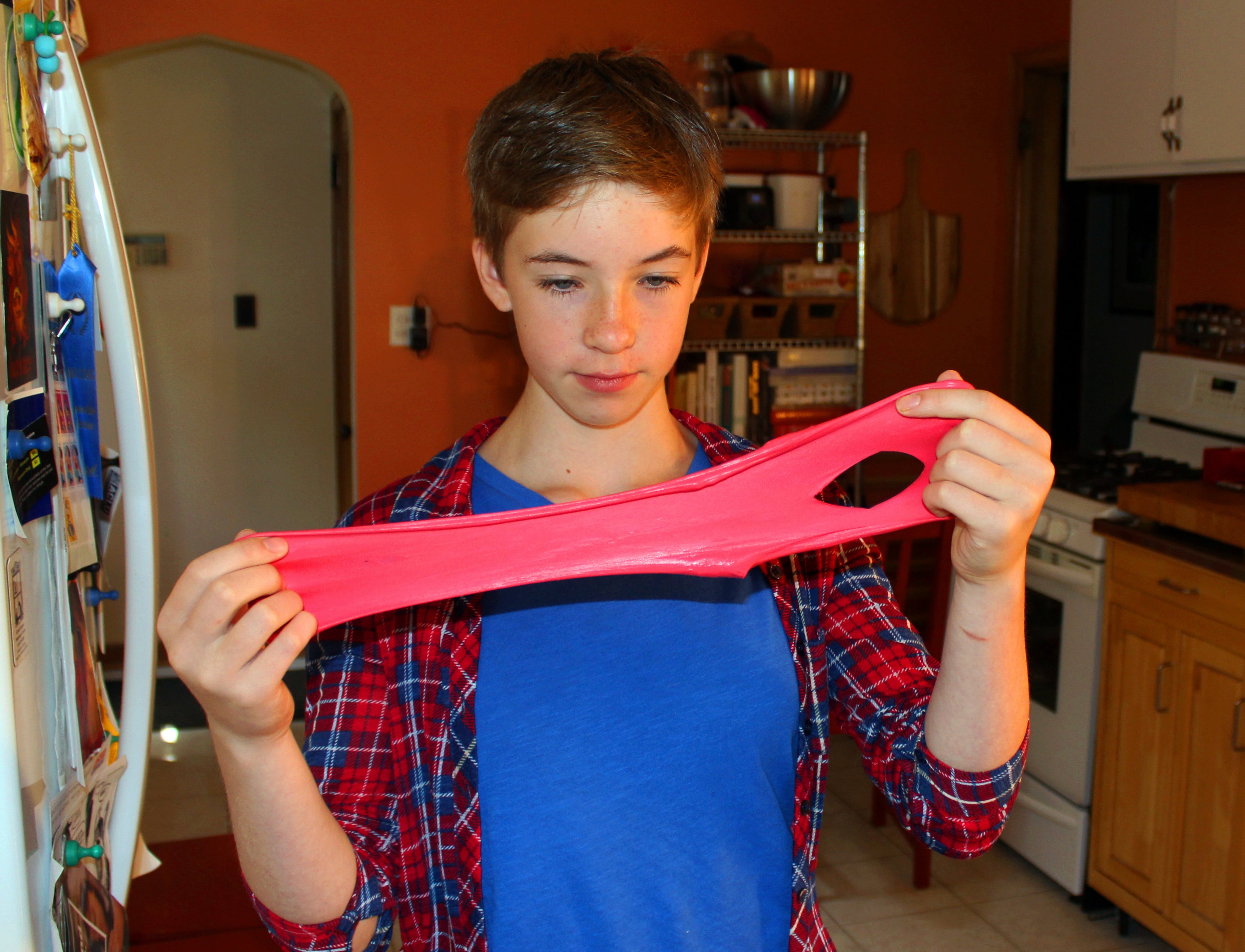 Astrid Rubens demonstrates the elasticity of homemade slime in her kitchen in St. Paul, Minn., June 21, 2017. (AP Photos/Jeff Baenen, File)