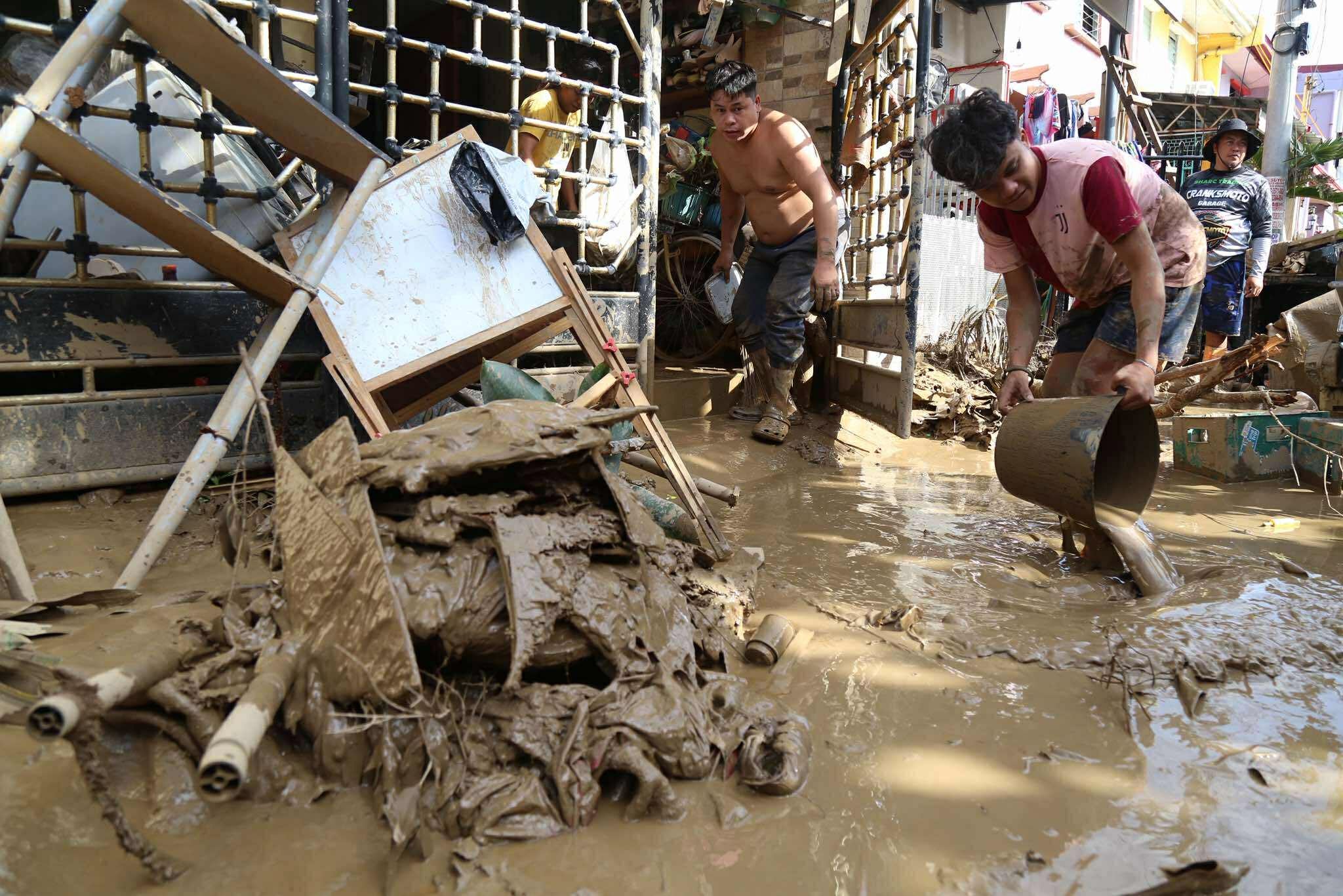 Residents clean up outside their homes after Kalmaegi caused devastation in Talisay city of Cebu province in the Philippines