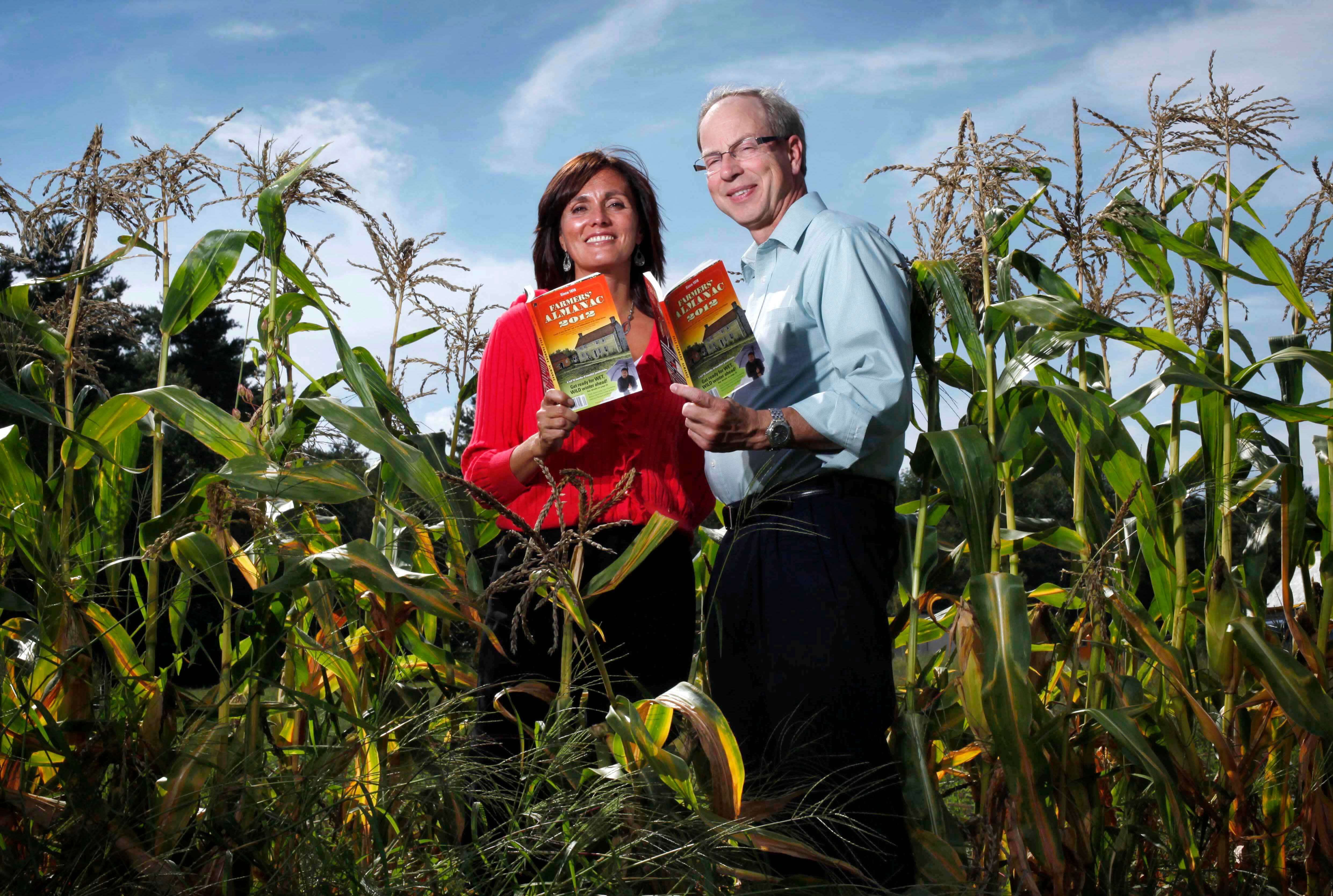 Farmers' Almanac editor Sandi Duncan and publisher Peter Geiger pose in a corn field with the 2012 edition of the almanac in Auburn, Maine