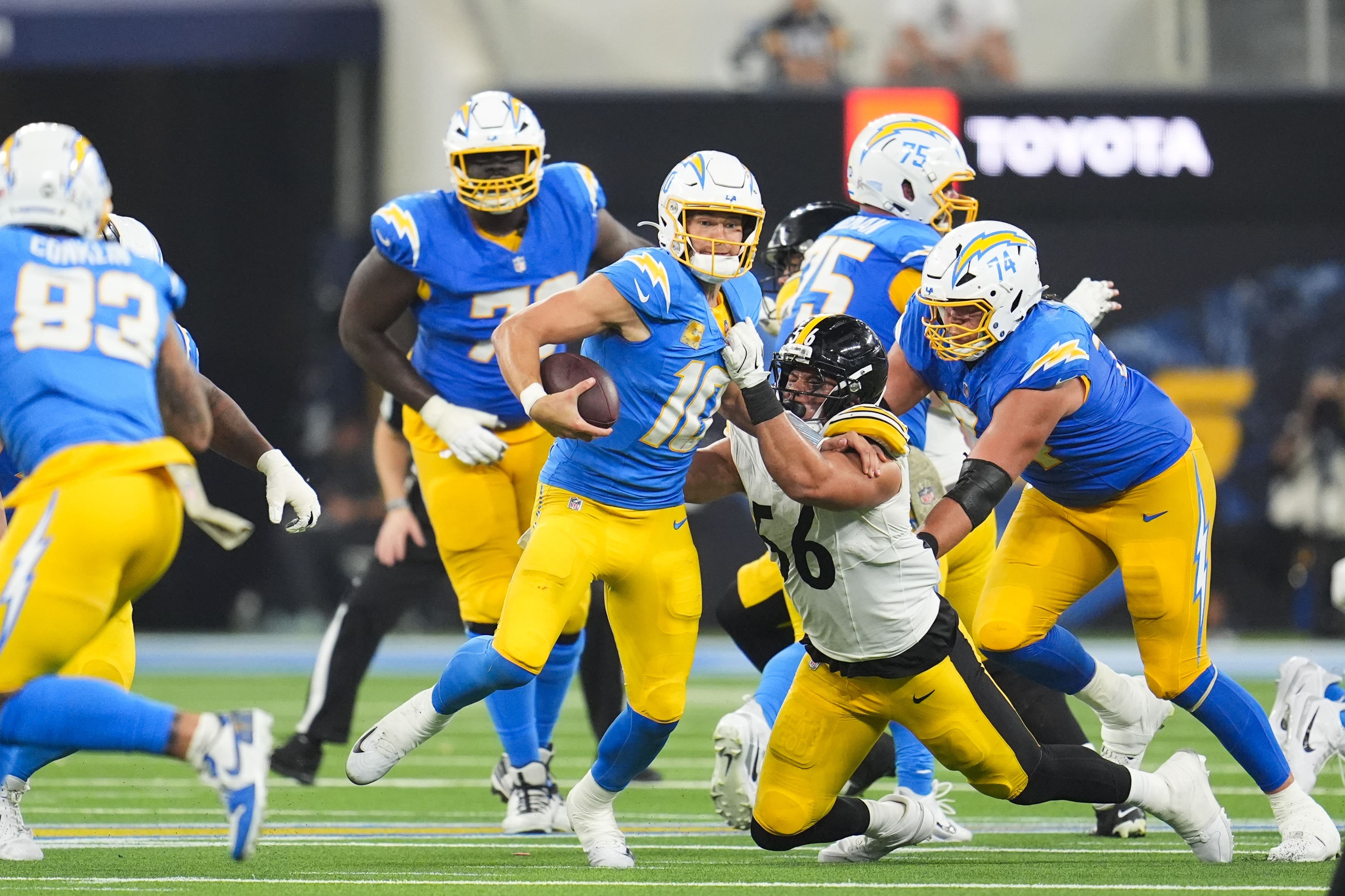 Pittsburgh Steelers linebacker Alex Highsmith grabs the jersey of Los Angeles Chargers quarterback Justin Herbert (Marcio Jose Sanchez/AP)