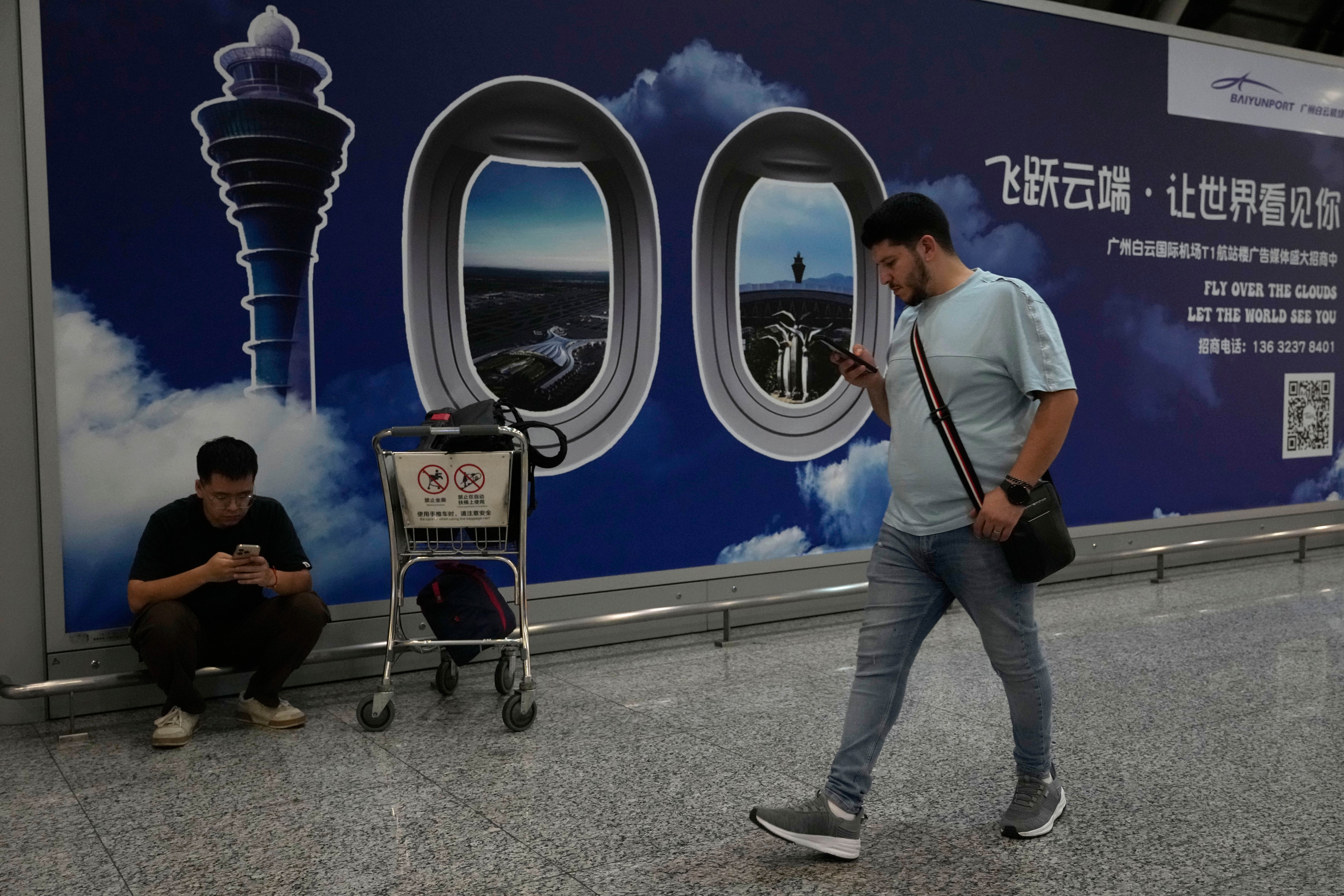 A person walks past a sign board for the Baiyun airport in Guangzhou in southern China's Guangdong province