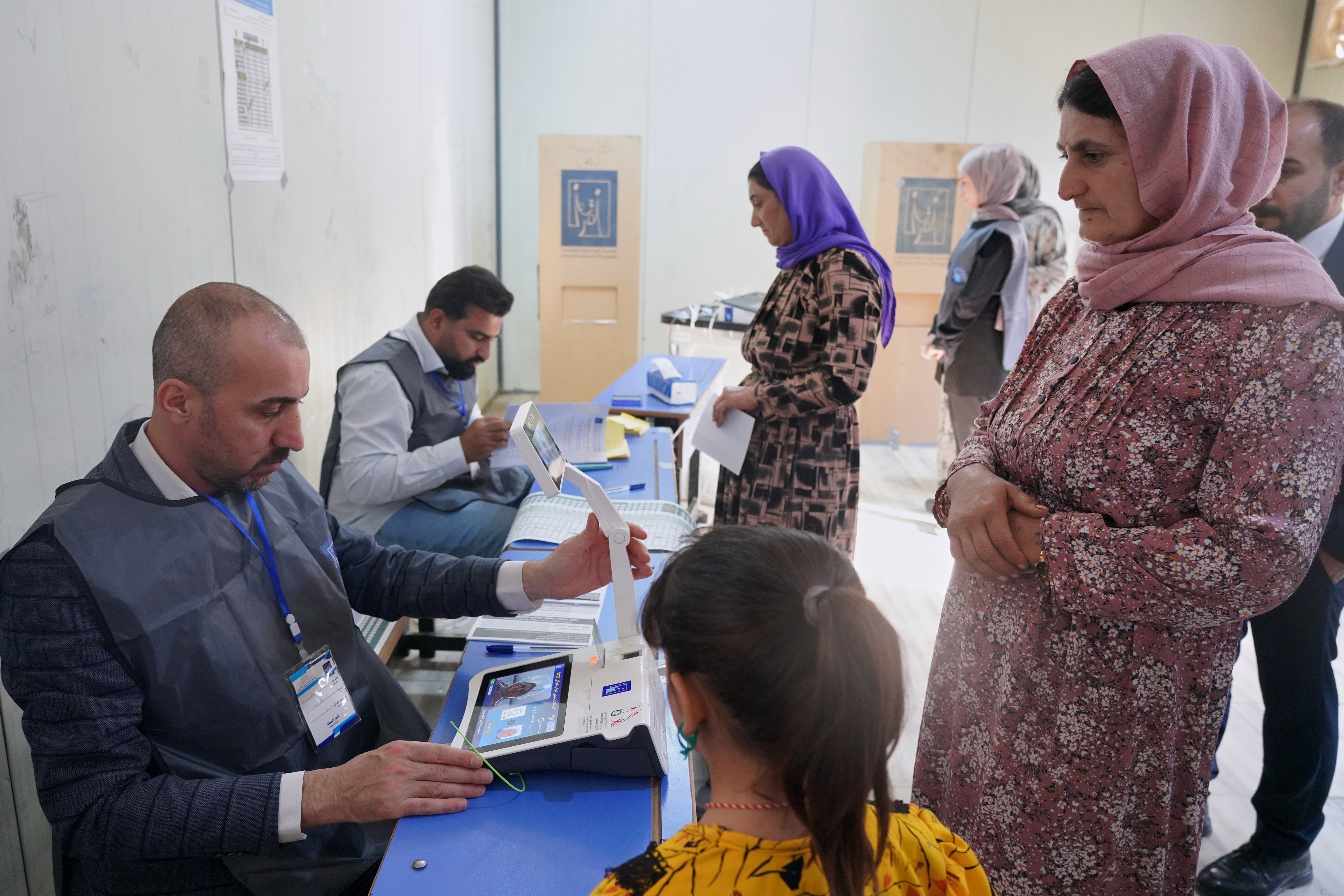 Displaced Yazidi women have their fingerprints verified before voting ahead of Iraq's parliamentary elections