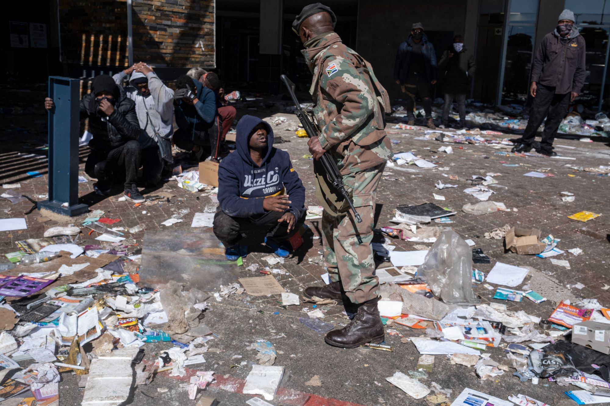 A suspected looter pleads with a soldier detaining suspected looters at the Jabulani mall in Soweto in 2021