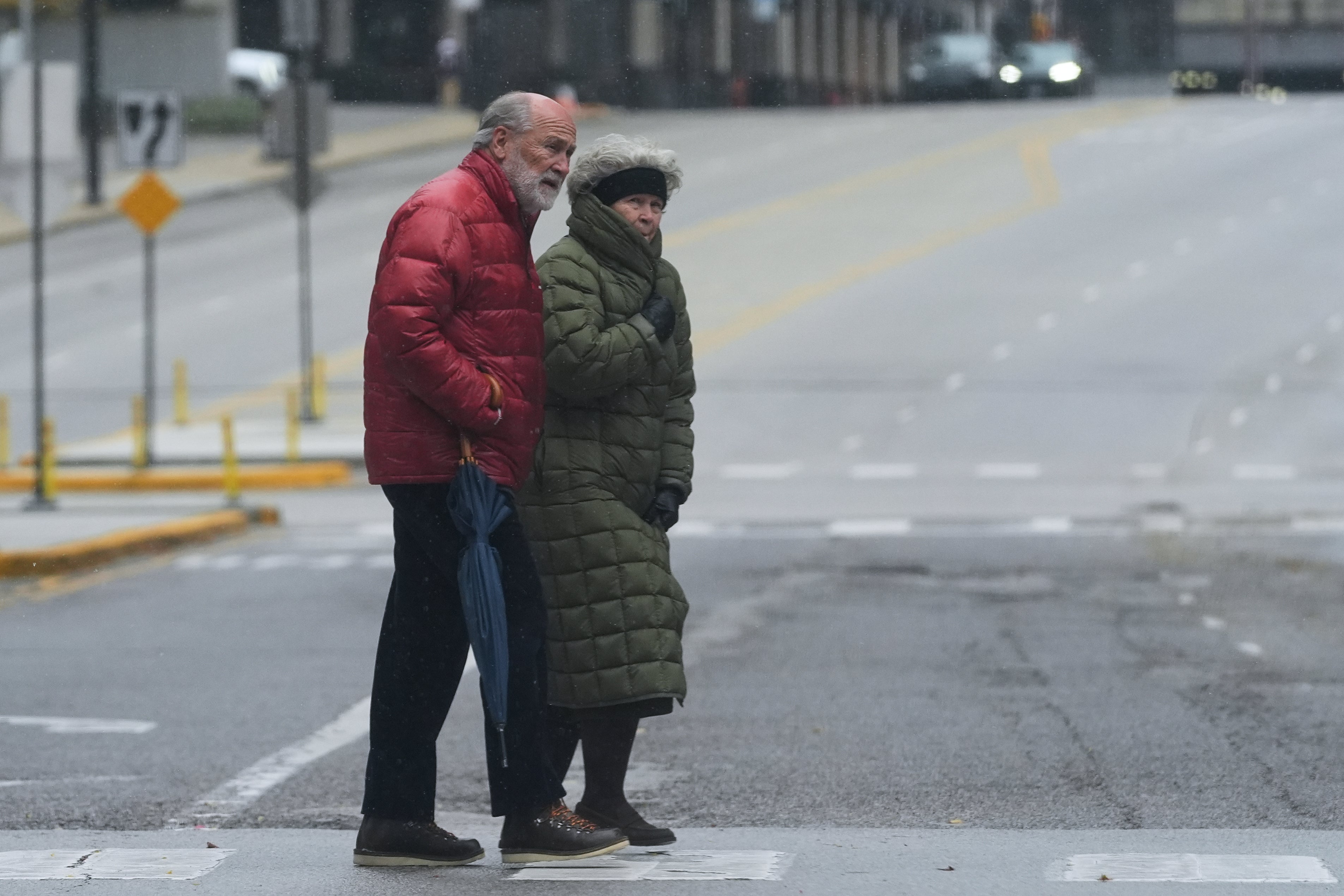 Pedestrians cross a street during a cold day in Chicago, Sunday, Nov. 9, 2025