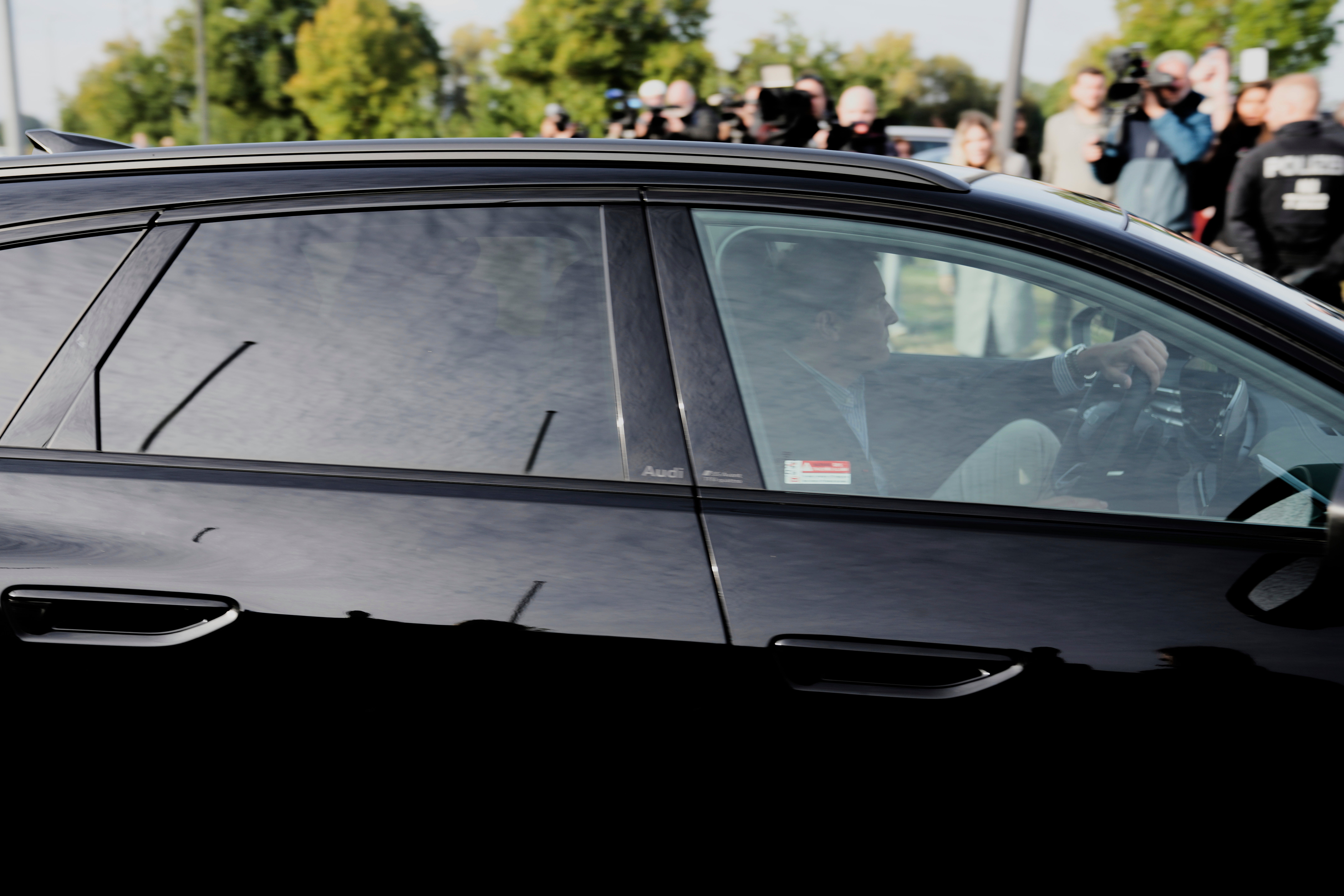 Lawyer Friedrich Fuelscher leaves a German prison in a black car carrying Christian Brückner, a suspect in the 2007 disappearance of British toddler Madeleine McCann, who sits in the back seat behind tinted windows