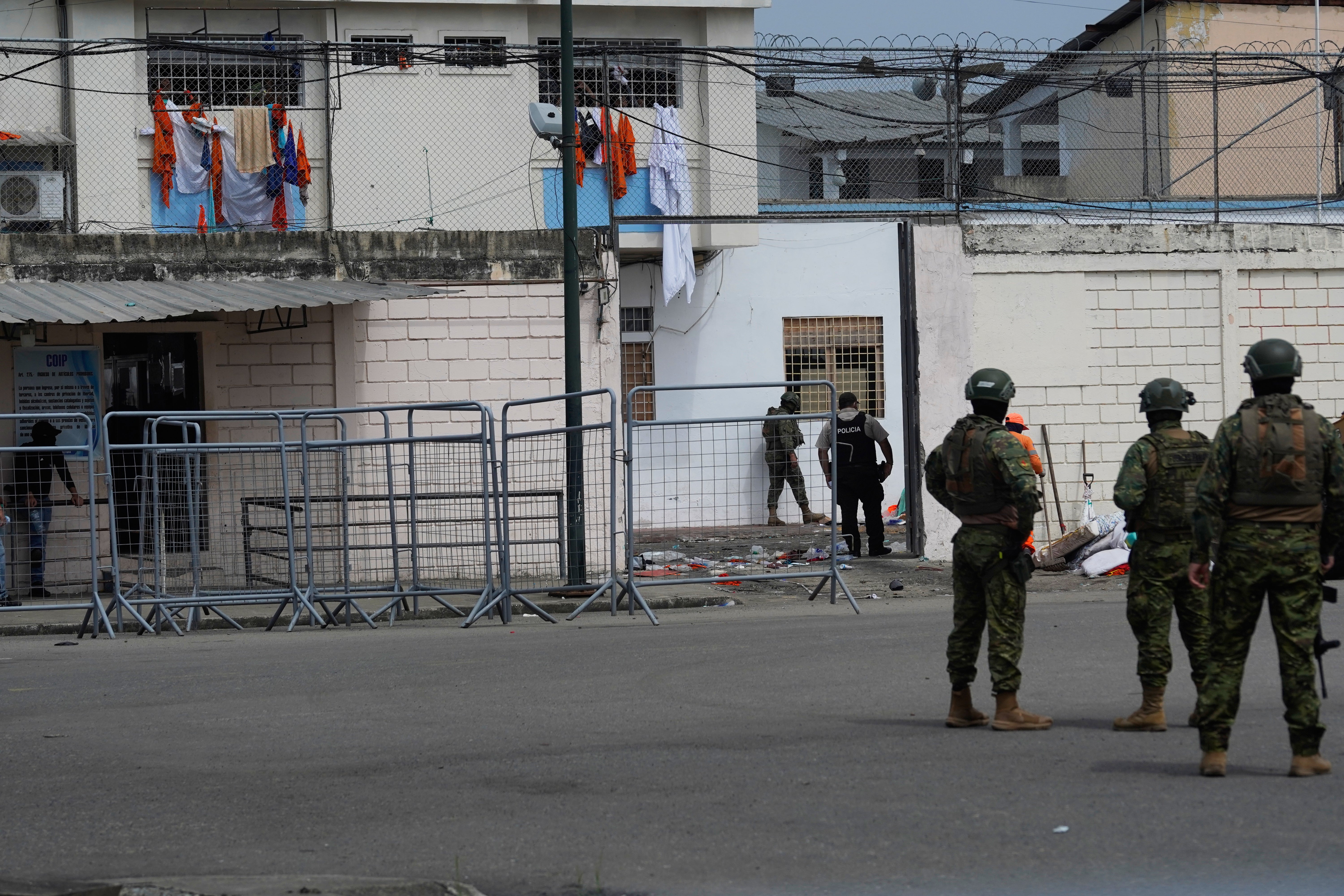 Soldiers stand guard outside the prison where inmates were killed during clashes between themselves in Machala, Ecuador