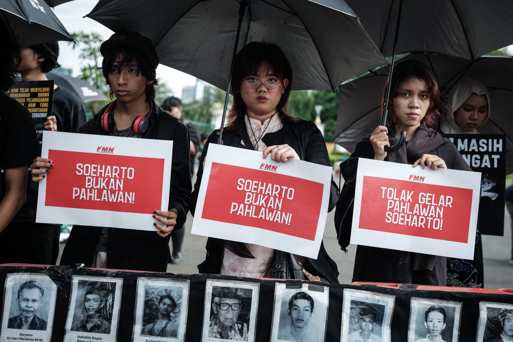Members of civil society groups hold posters reading ‘Suharto is not a hero’ during a rally opposing the government’s plan to grant the former president the title of national hero near the presidential palace in Jakarta on 6 November 2025