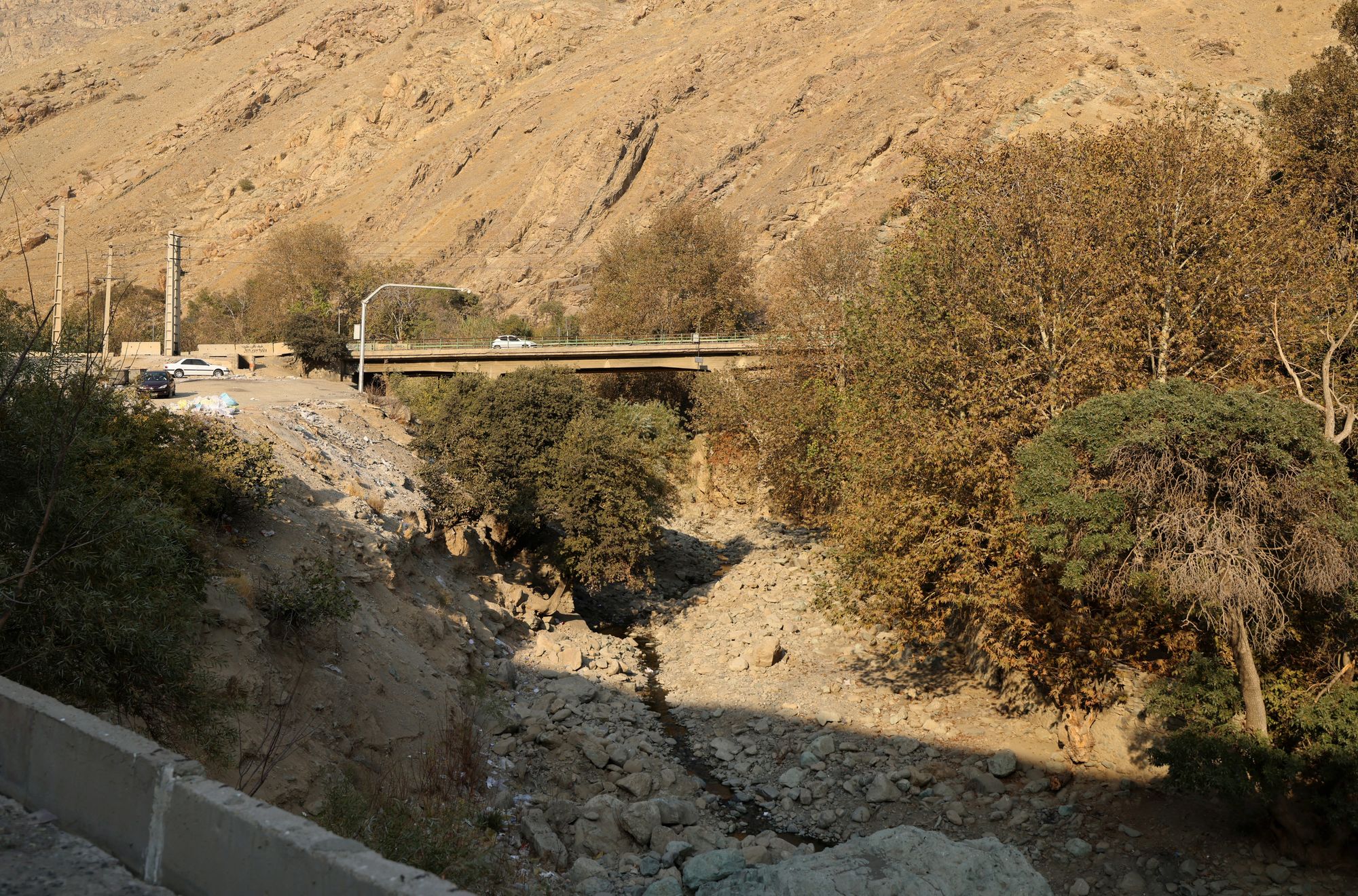 A car drives over a bridge crossing the dried-up Kan River, west of Tehran, on 9 November