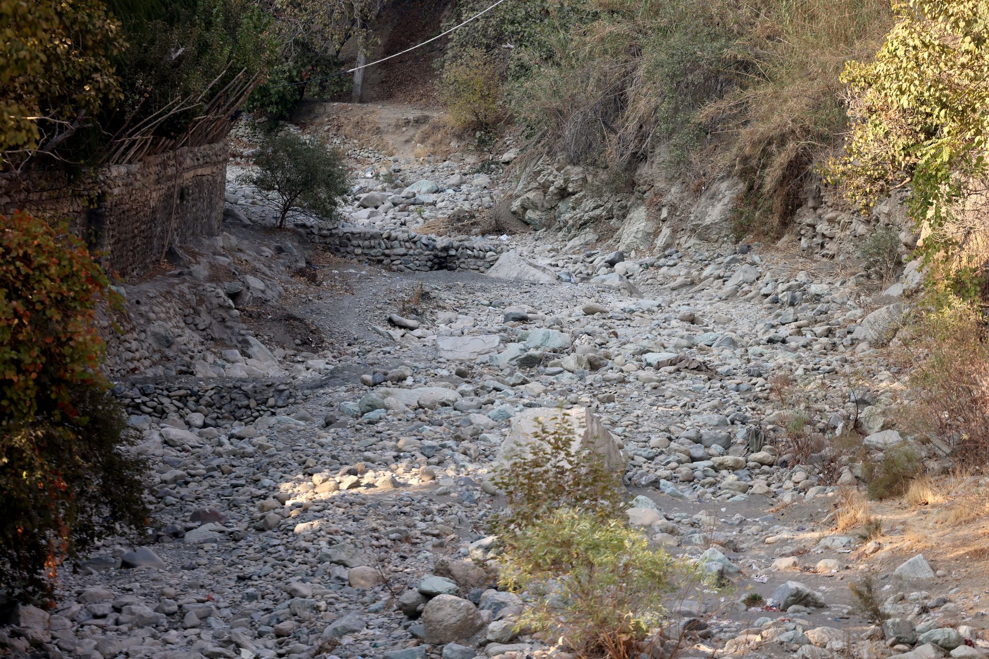 Rocks and pebbles cover the bed of the dried-up Kan River, west of Tehran, on 9 November 2025
