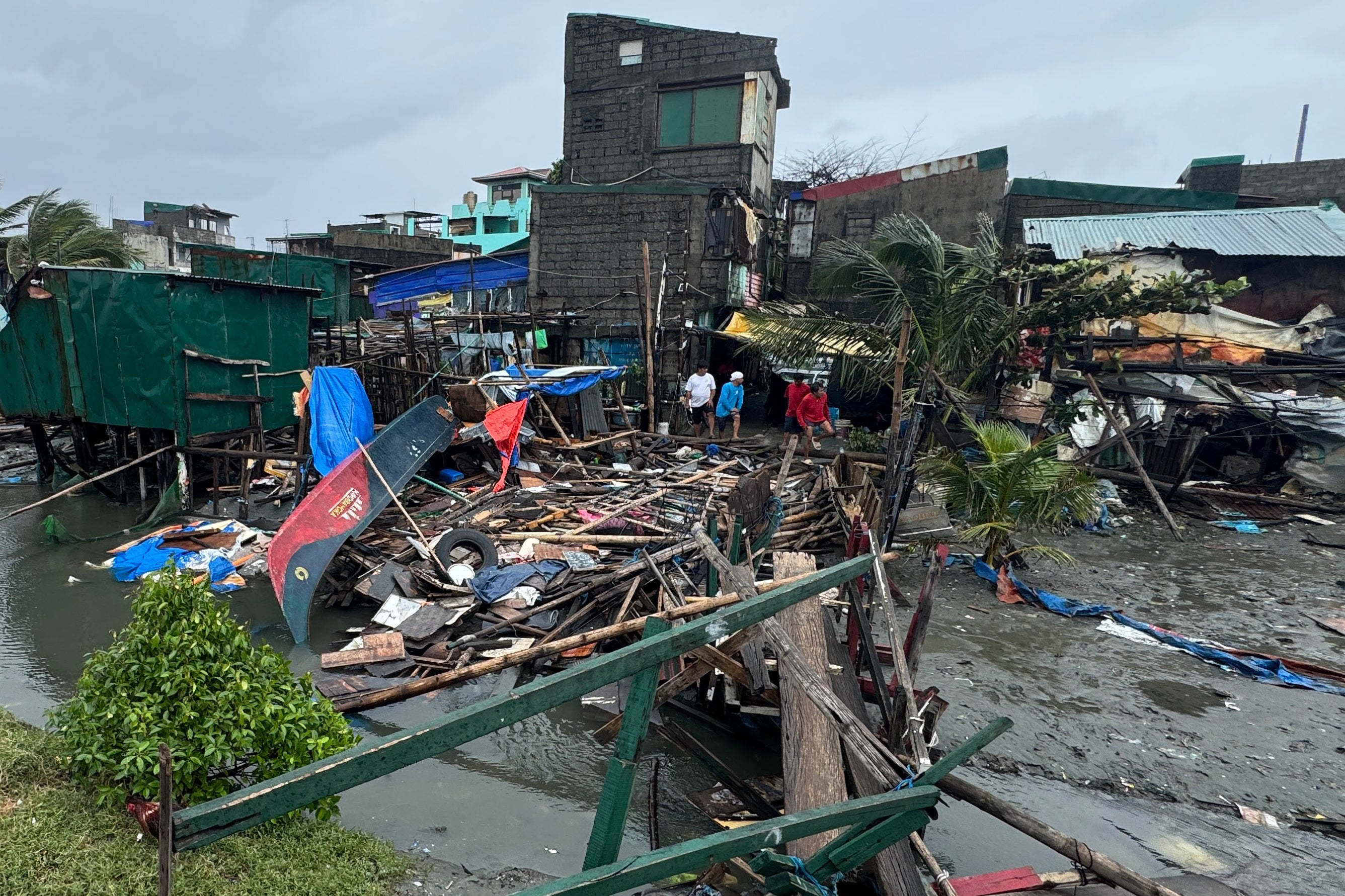 <p>A damaged house and toppled bridge in the storm-hit coastal village of Navotas</p>