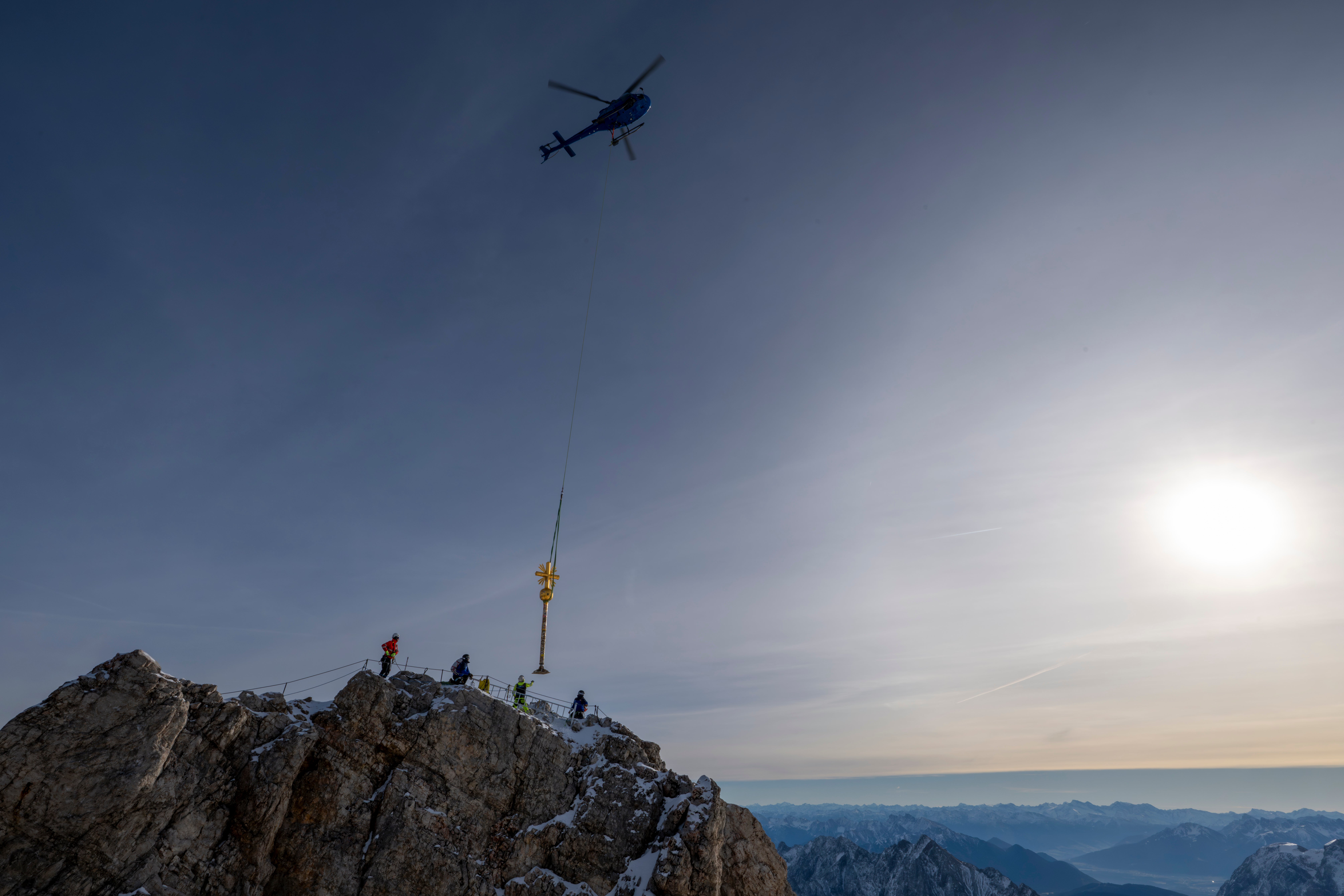 A gilded cross is removed from Zugspitze peak by helicopter