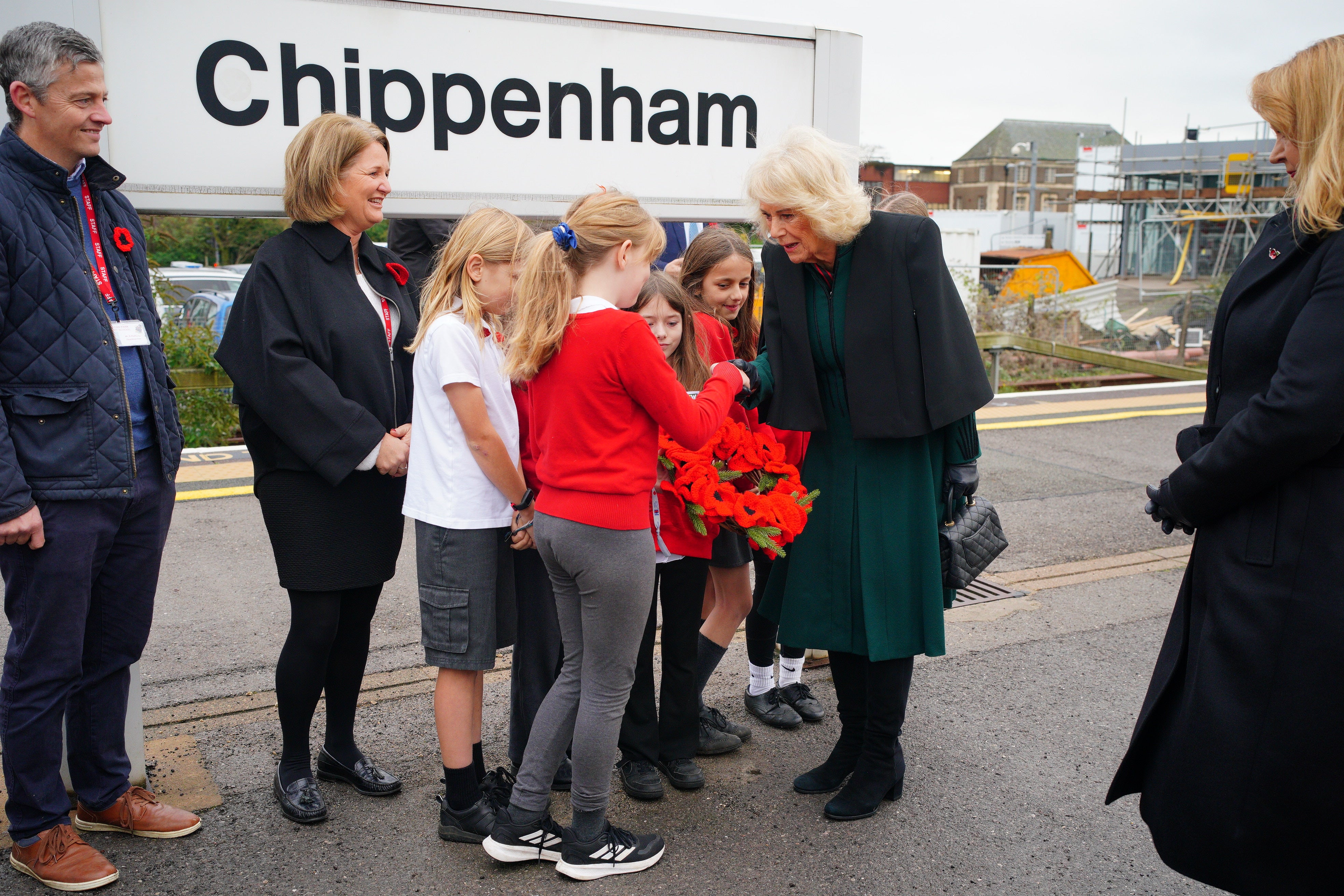 Queen Camilla is presented with a crocheted poppy wreath by Eira Jones, 10 at Chippenham station