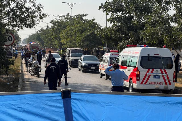 <p>Police officers and ambulances on the road, which is cordoned off, after a blast outside a court building in Islamabad, Pakistan, 11 November 2025</p>