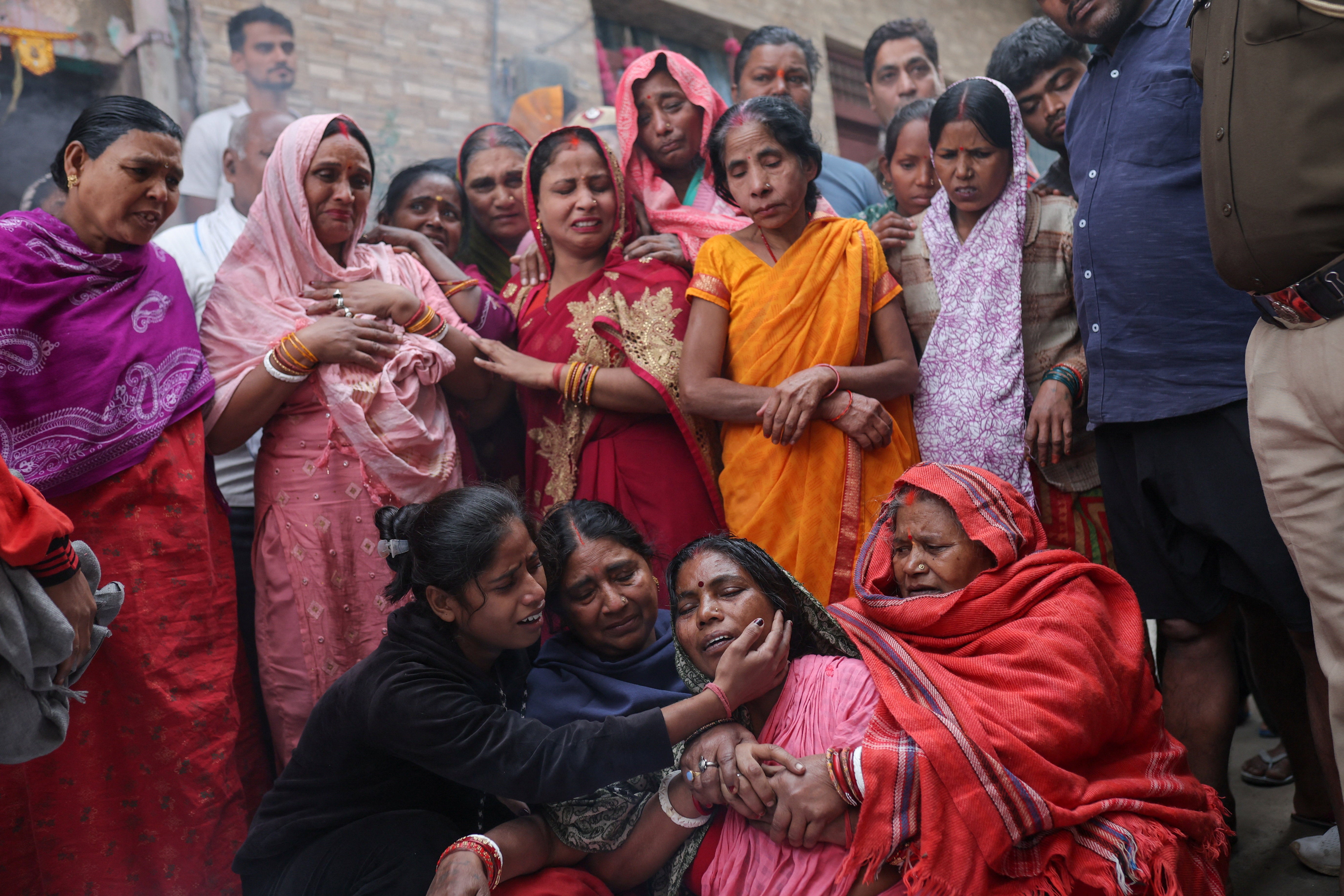 Family members of Pankaj Saini, who died in the Delhi explosion, mourn as his body is brought to their home ahead of the funeral