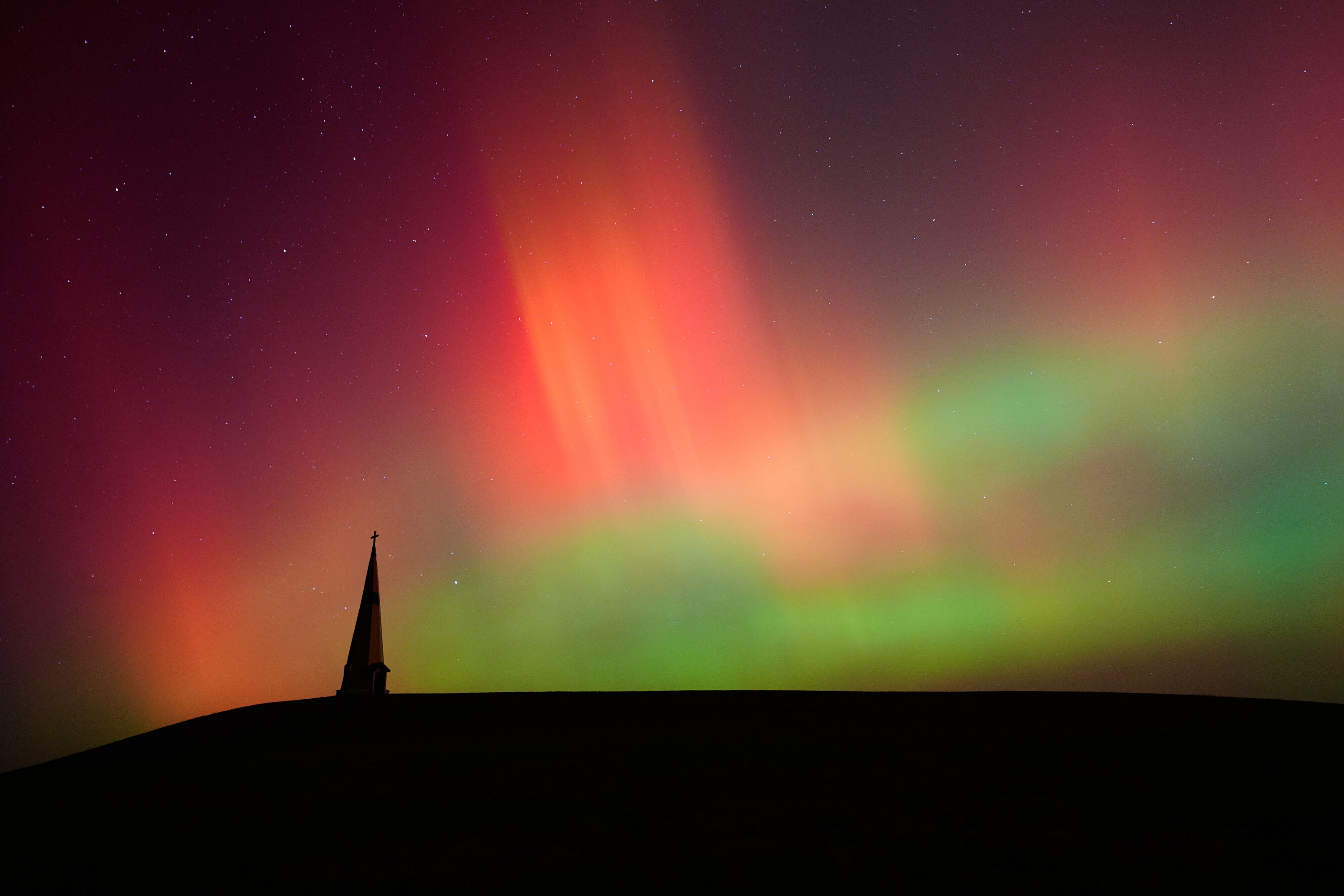 <p>The northern lights fill the sky behind the Saint Joseph the Woodworker Shrine Tuesday, Nov. 11, 2025, near Valley Falls, Kan. </p>