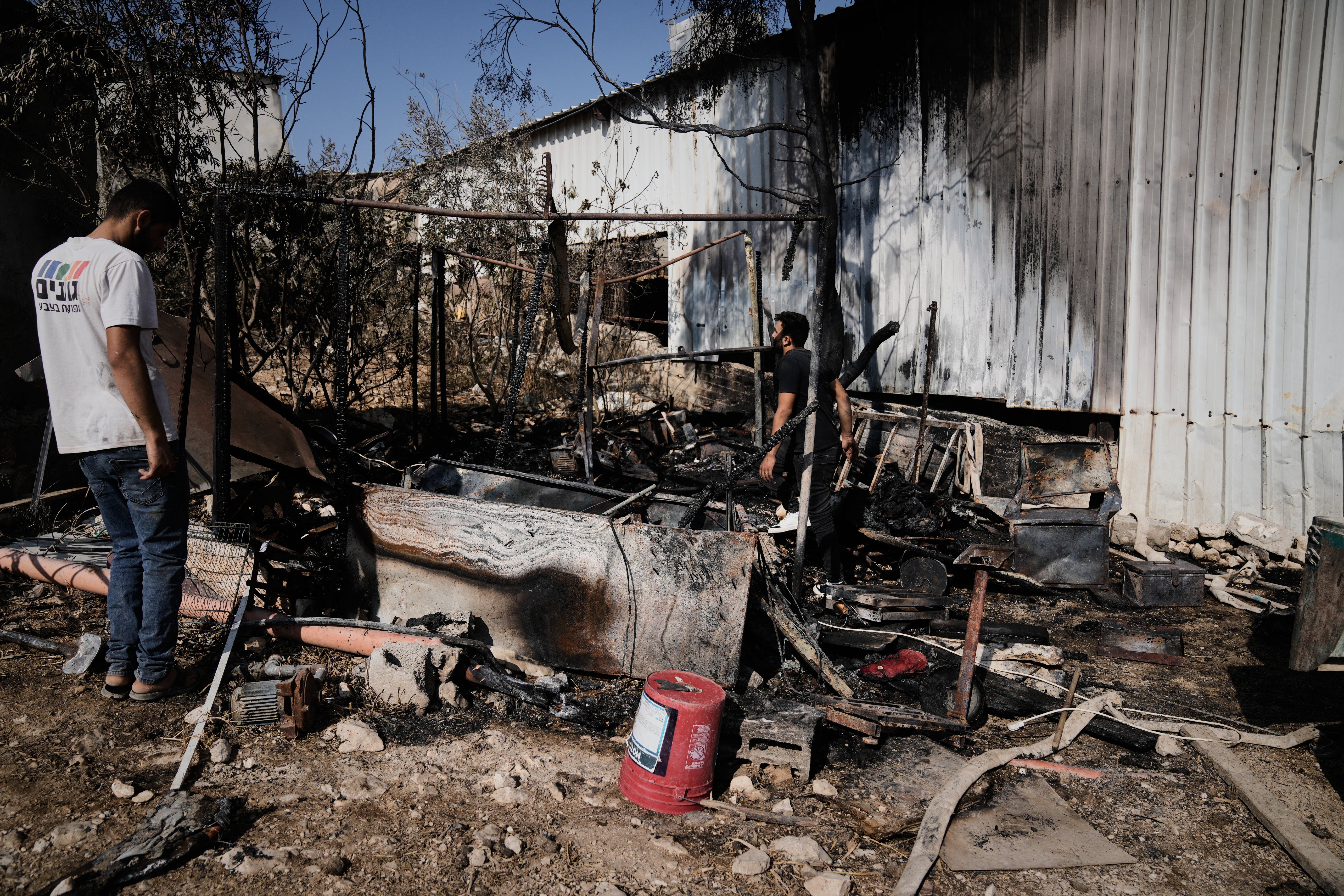 Palestinians survey damage in an industrial zone following an attack by Israeli settlers the previous day in the West Bank village of Beit Lid, near Tulkarm, Wednesday, Nov. 12, 2025. (AP Photo/Majdi Mohammed)