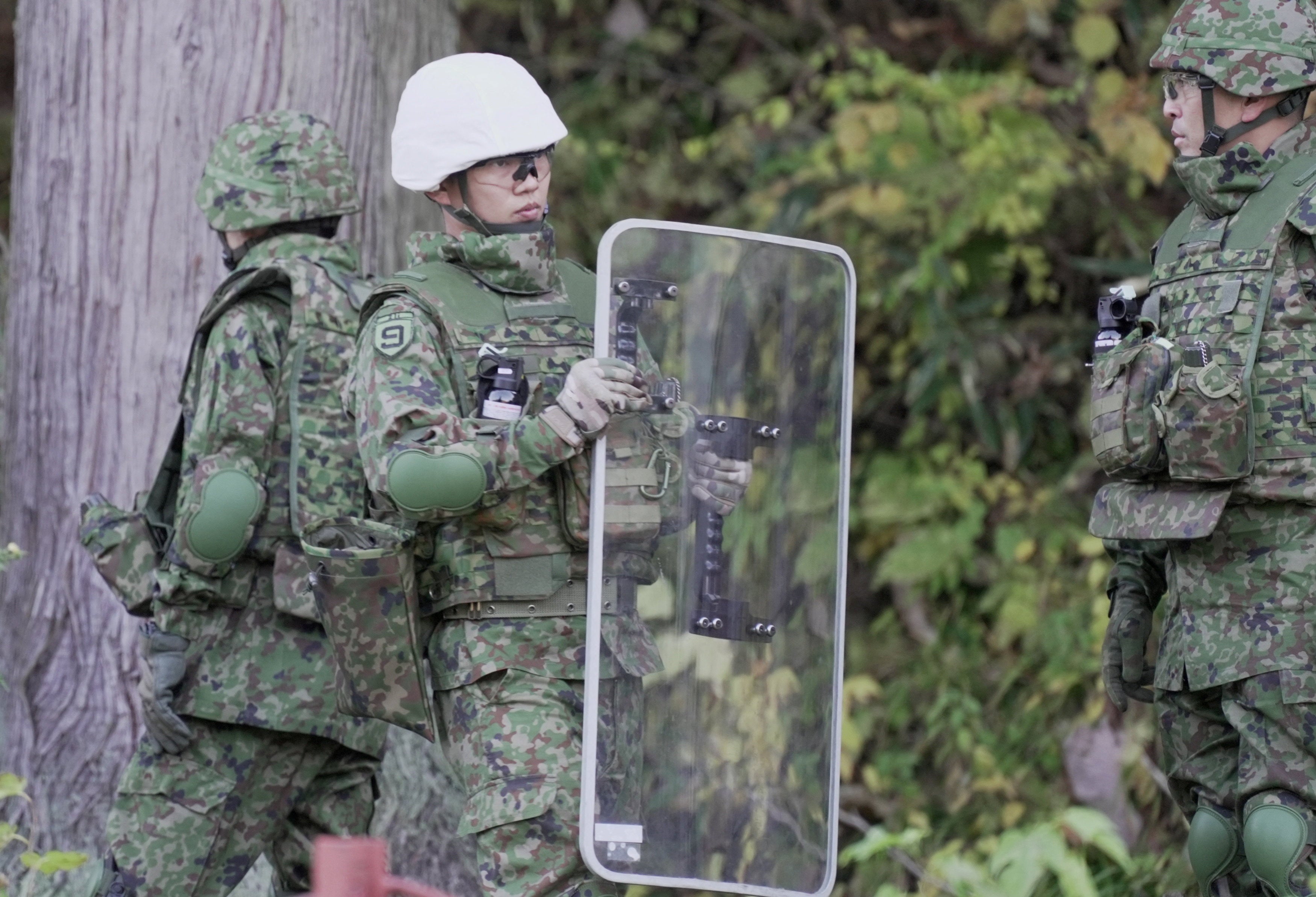 A member of Japan Self-Defence Forces (JSDF) holds a shield during a practice setting up a bear trap in Kazuno, Akita Prefecture, Japan, 5 November 2025