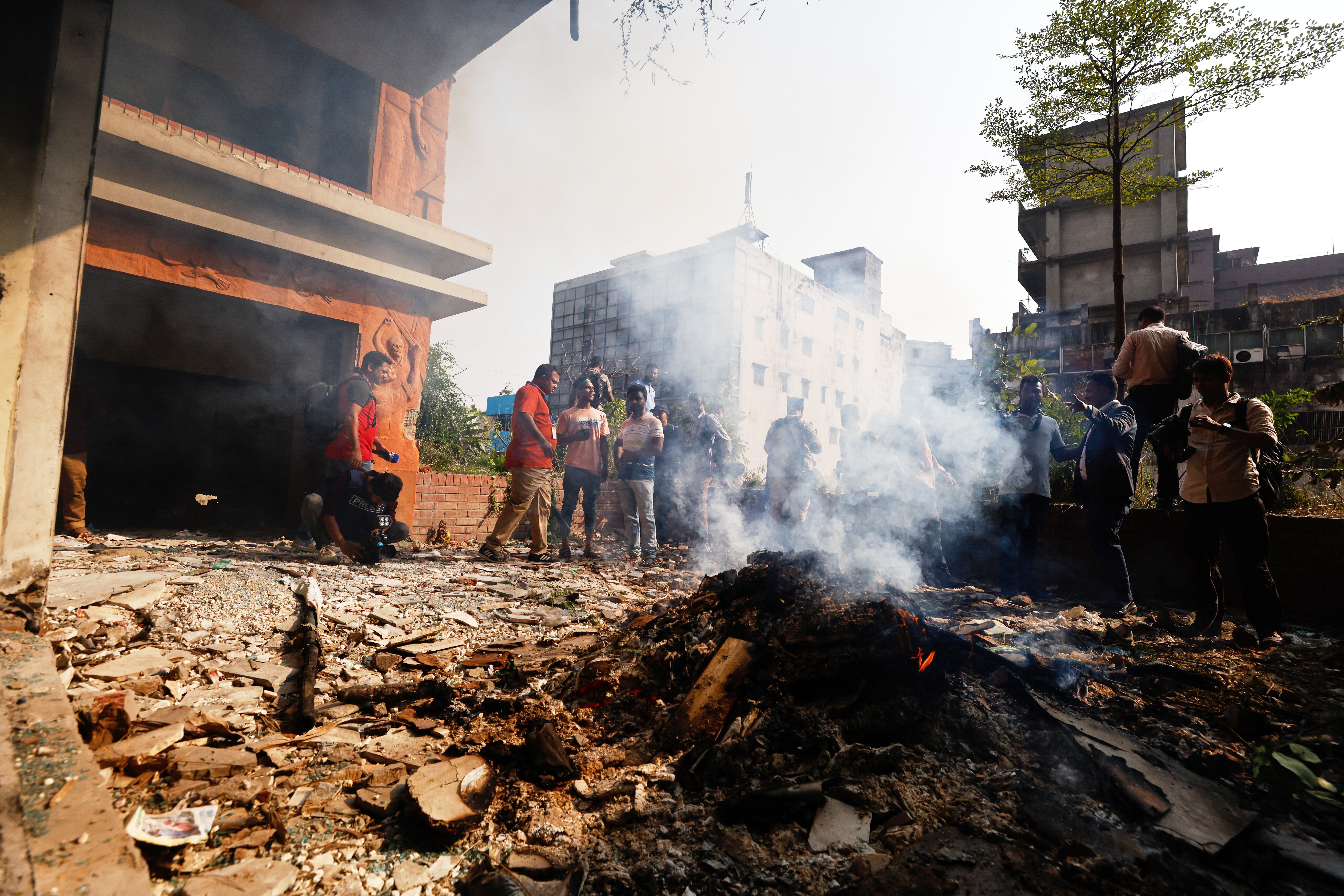 A fire smolders after protesters vandalise an office of ousted leader Sheikh Hasina’s Awami League party in Dhaka on 13 November 2025