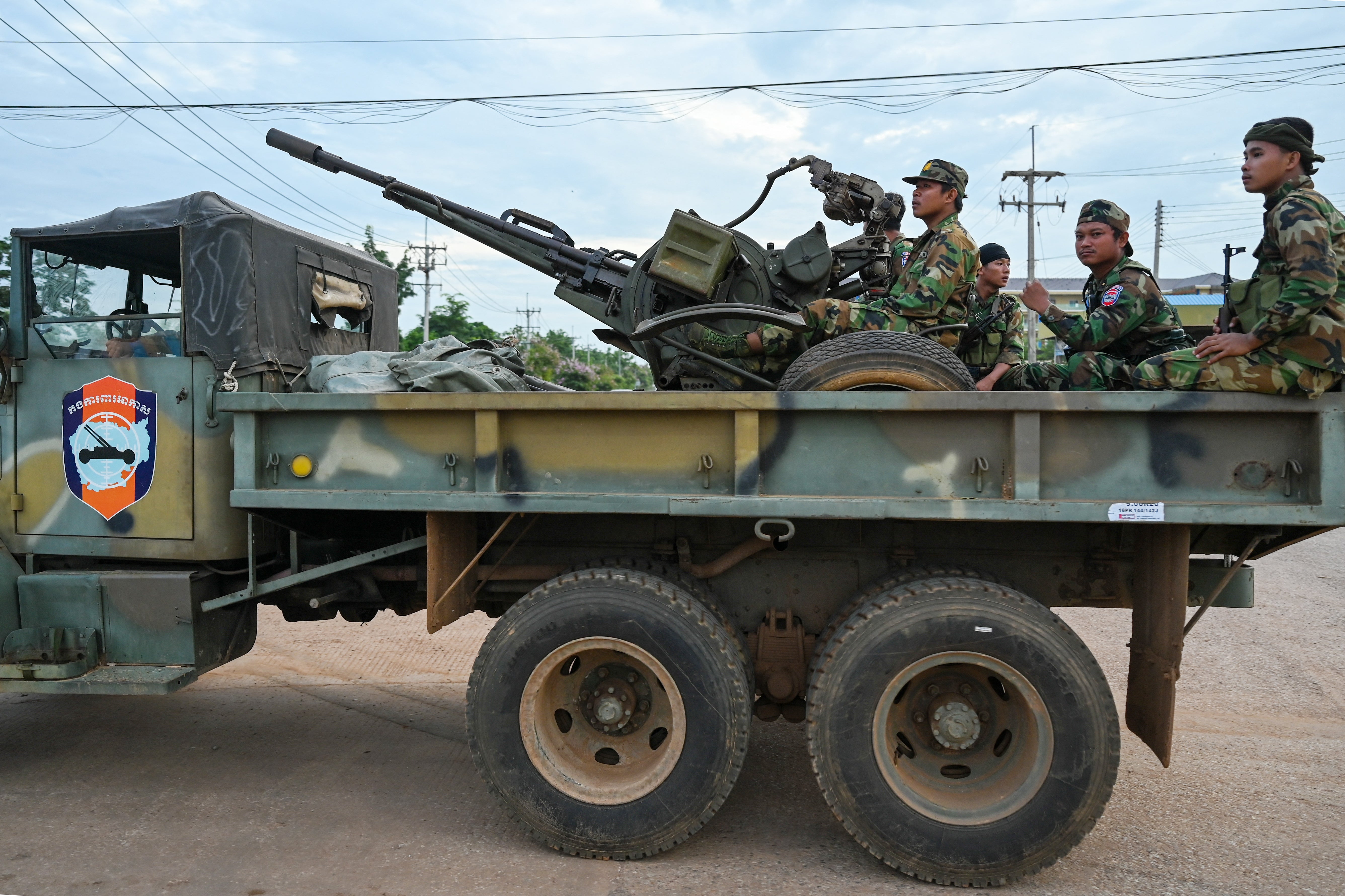 Cambodian soldiers stand on a military truck with an anti-aircraft gun in Oddar Meanchey province on 25 July 2025