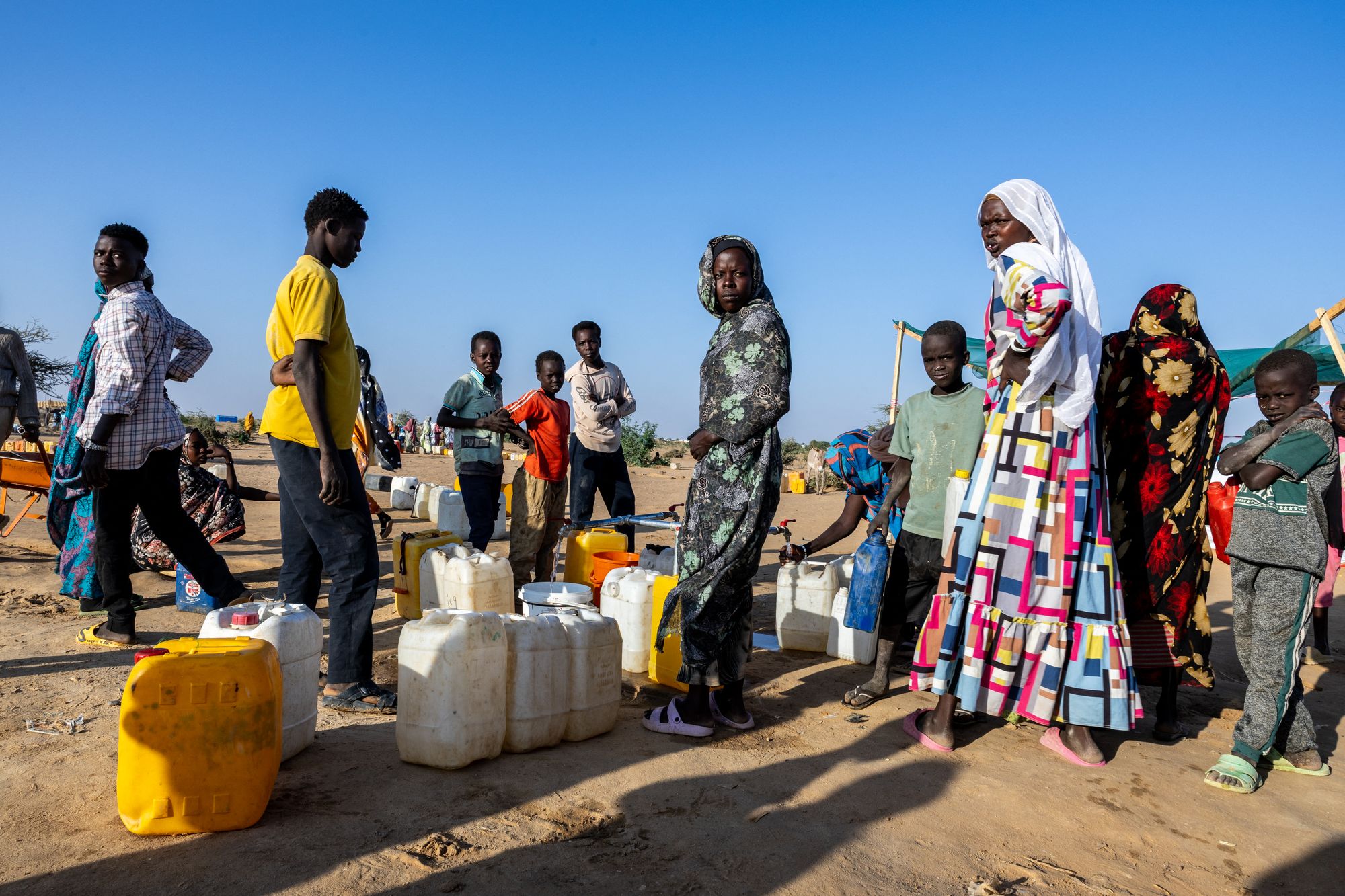 <p>Sudanese refugees queue to fill jerrycans with water at Oure Cassoni camp in Chad </p>