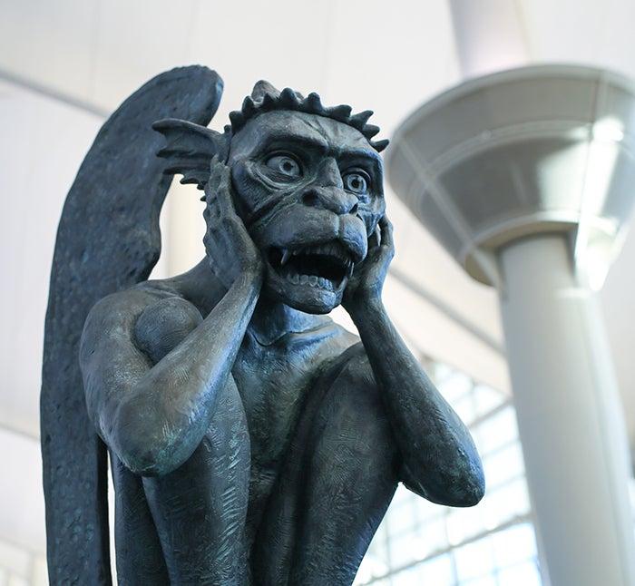 Gargoyles perch in open suitcases above the baggage claim