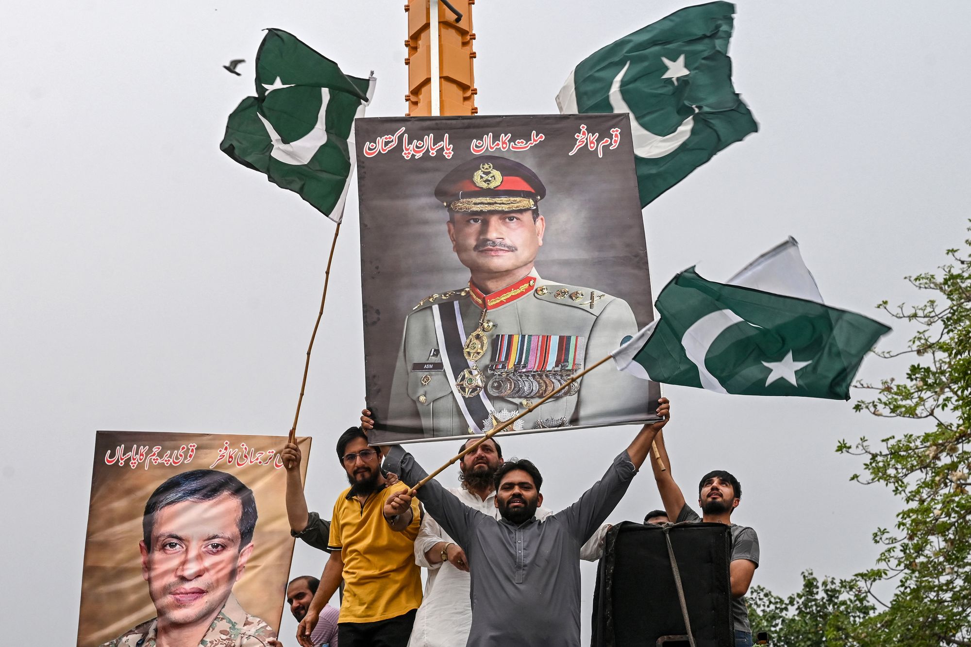 File. Demonstrators carrying posters with portraits of army chief Syed Asim Munir shout slogans as they participate in an anti-India protest in Lahore, Pakistan, on 11 May 2025