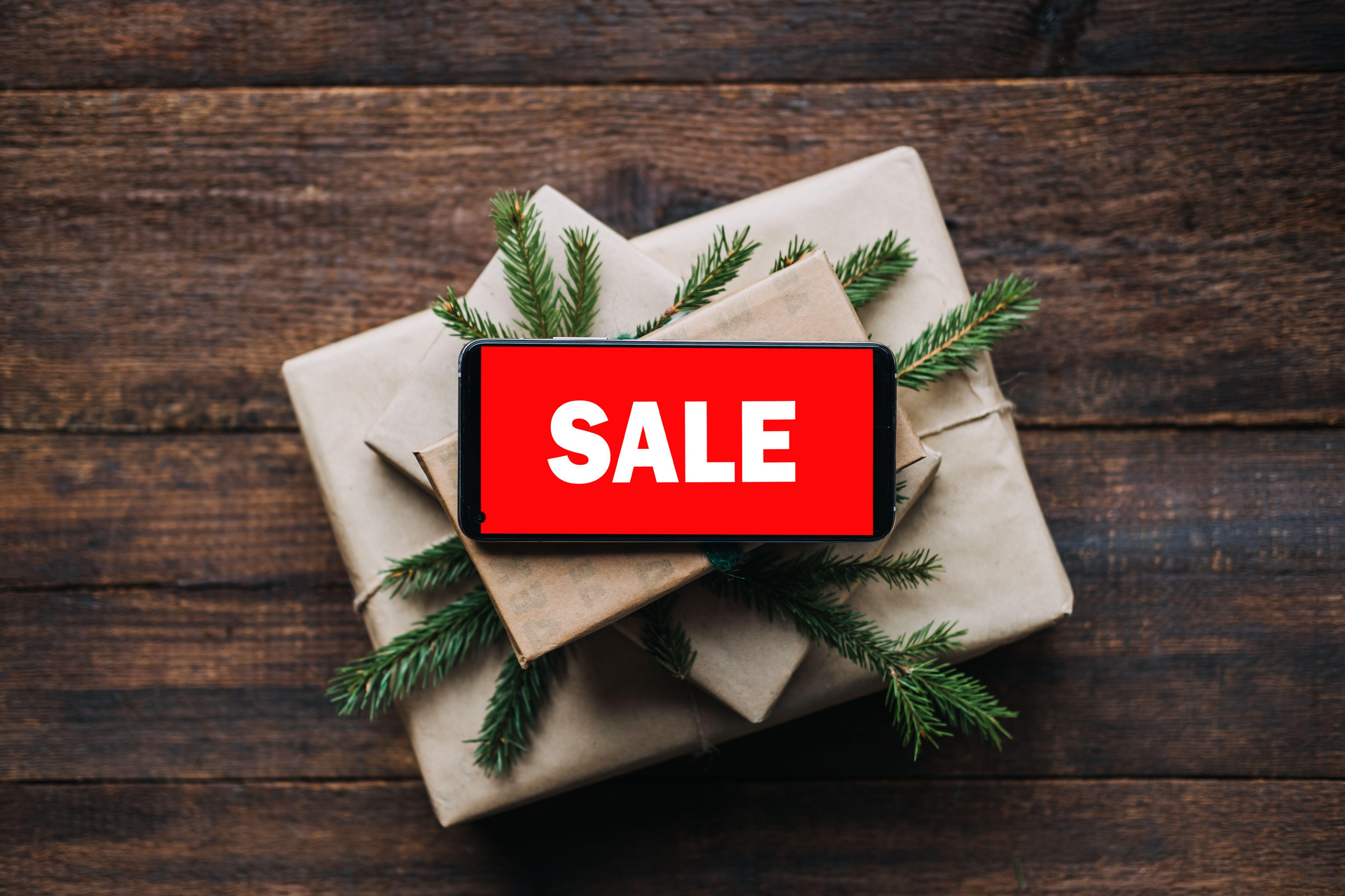 Sale sign on top of pile of Christmas presents