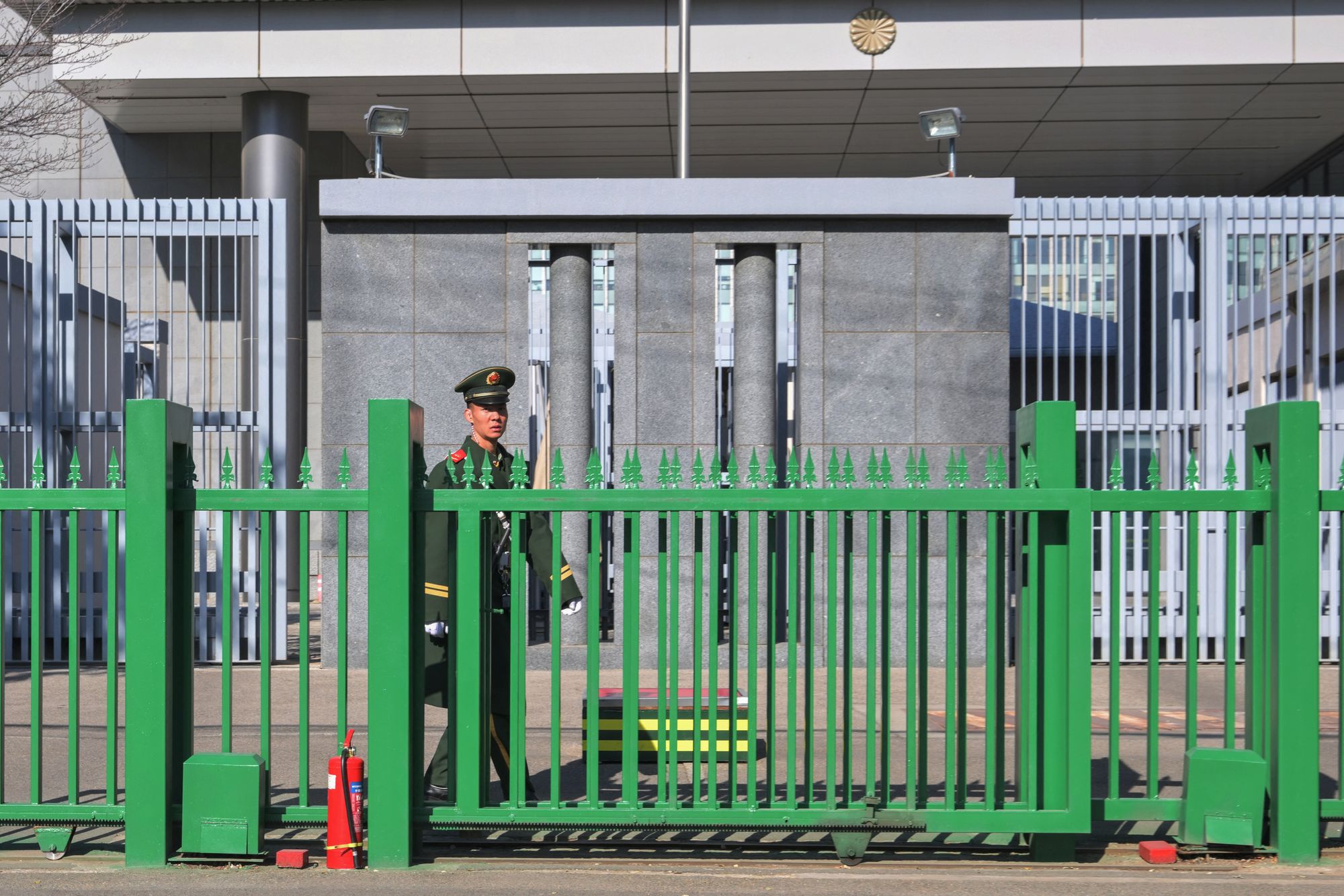 A member of security stands guard at the Japanese embassy in Beijing on 14 November 2025