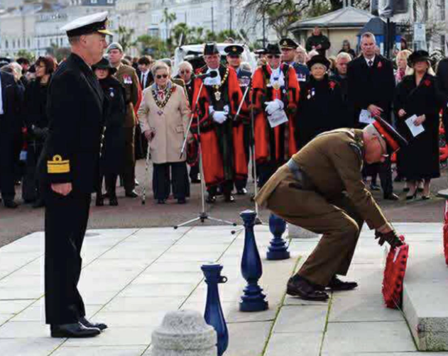 Carley watches another serviceman lay the poppy wreath at Llandudno’s war memorial