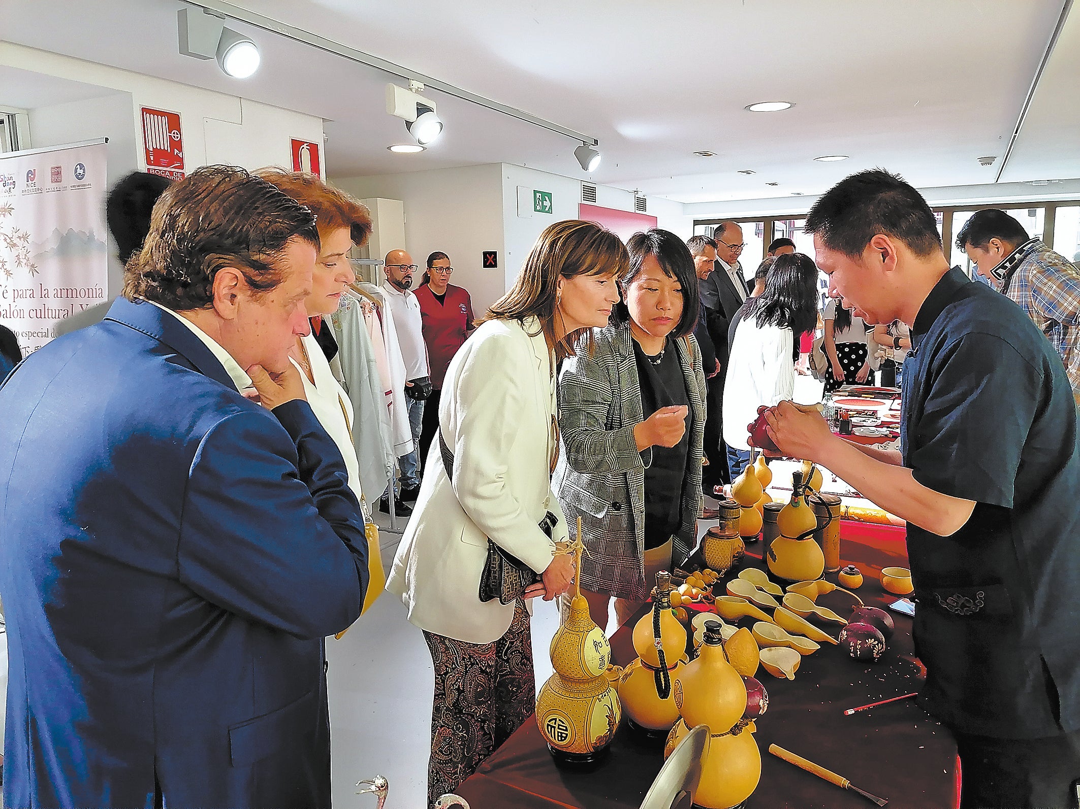 Wang Shufeng (right) displays gourd products to visitors during a cultural exchange at a Chinese culture centre in Madrid, Spain