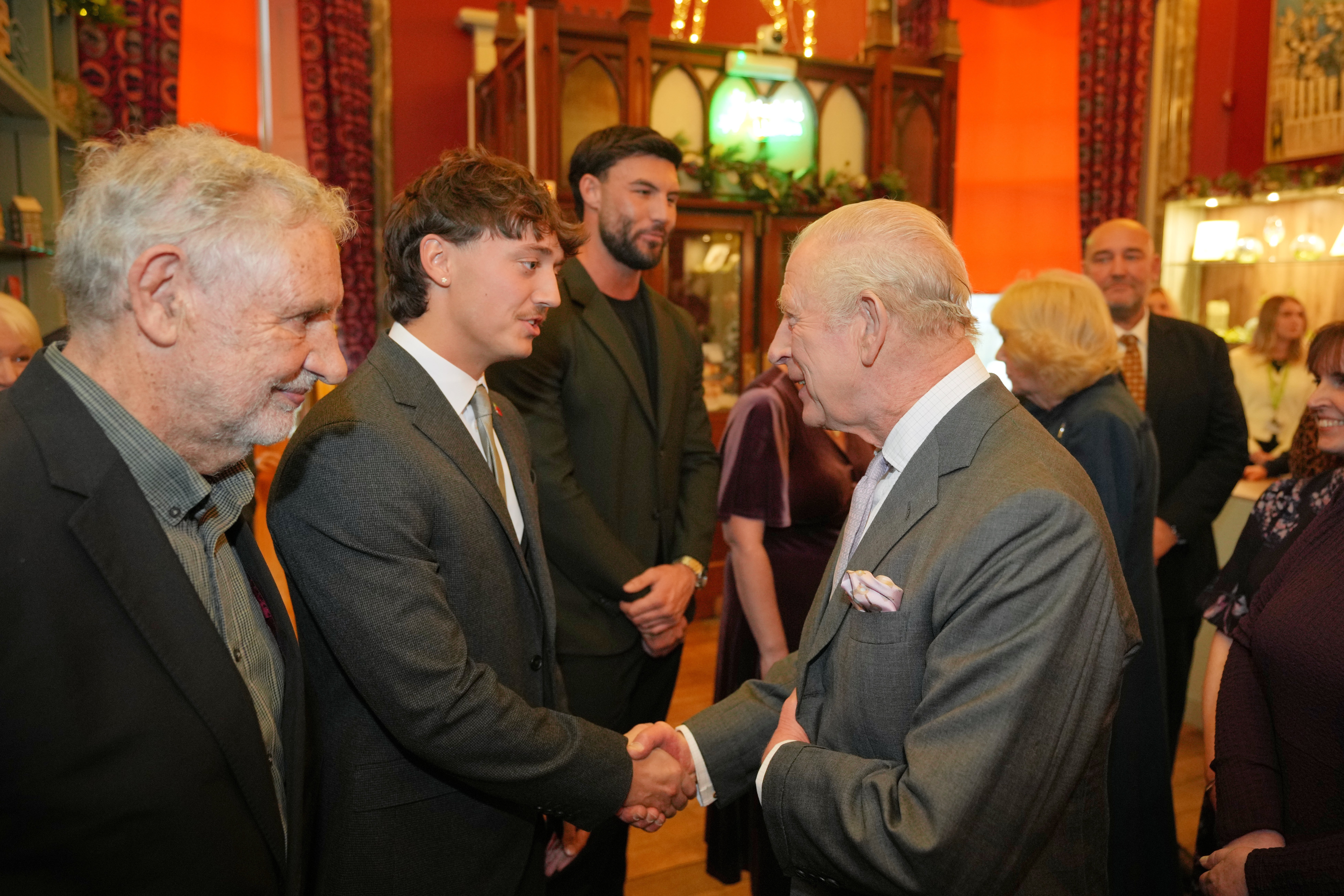 The King shakes hands with Lewis Leigh (second left) during a visit to Cyfarthfa Castle in Merthyr Tydfil, South Wales (Kin Cheung/PA)