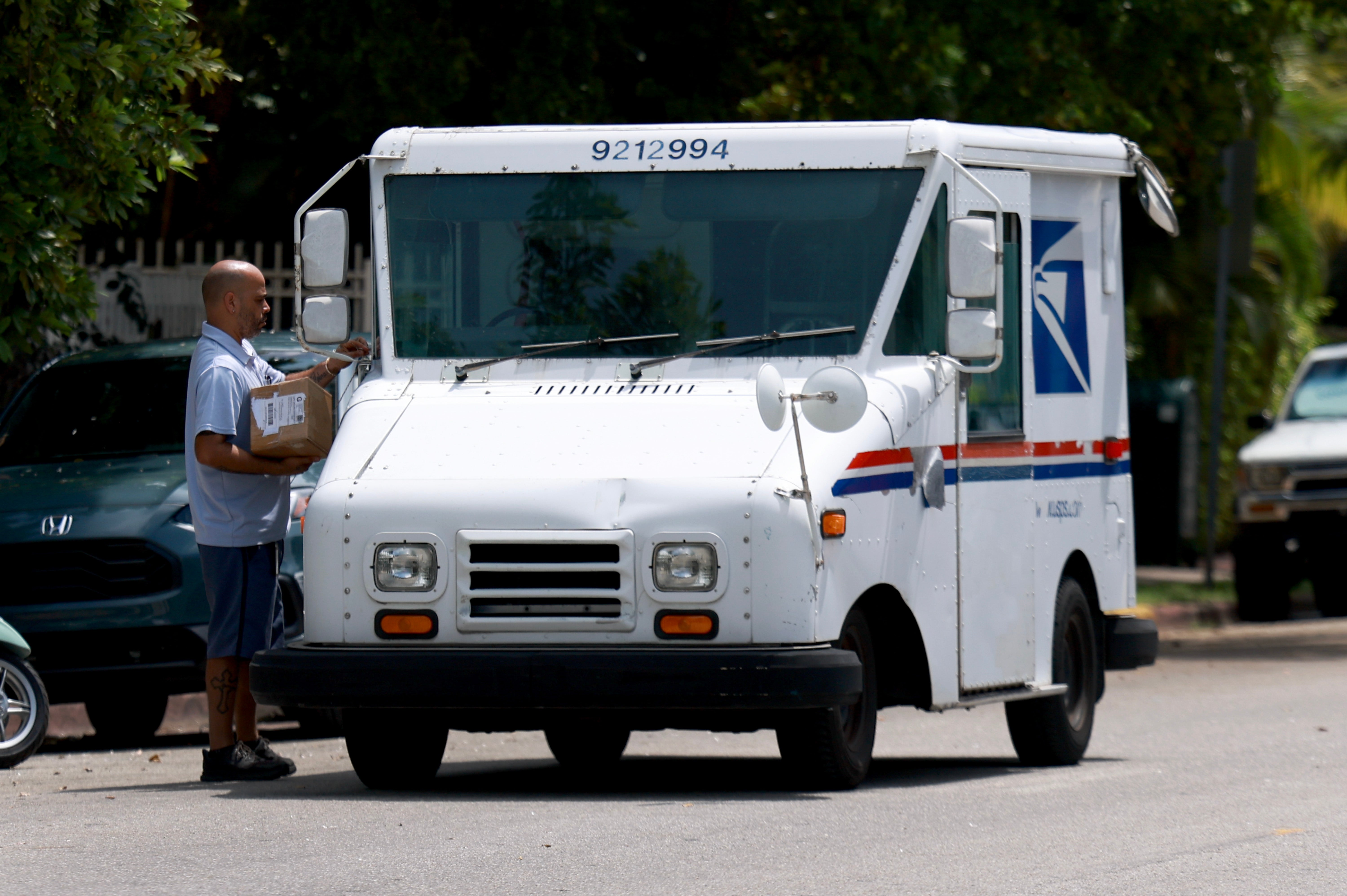 A United States Postal Service person delivers mail on September 12, 2024 in Miami Beach, Florida