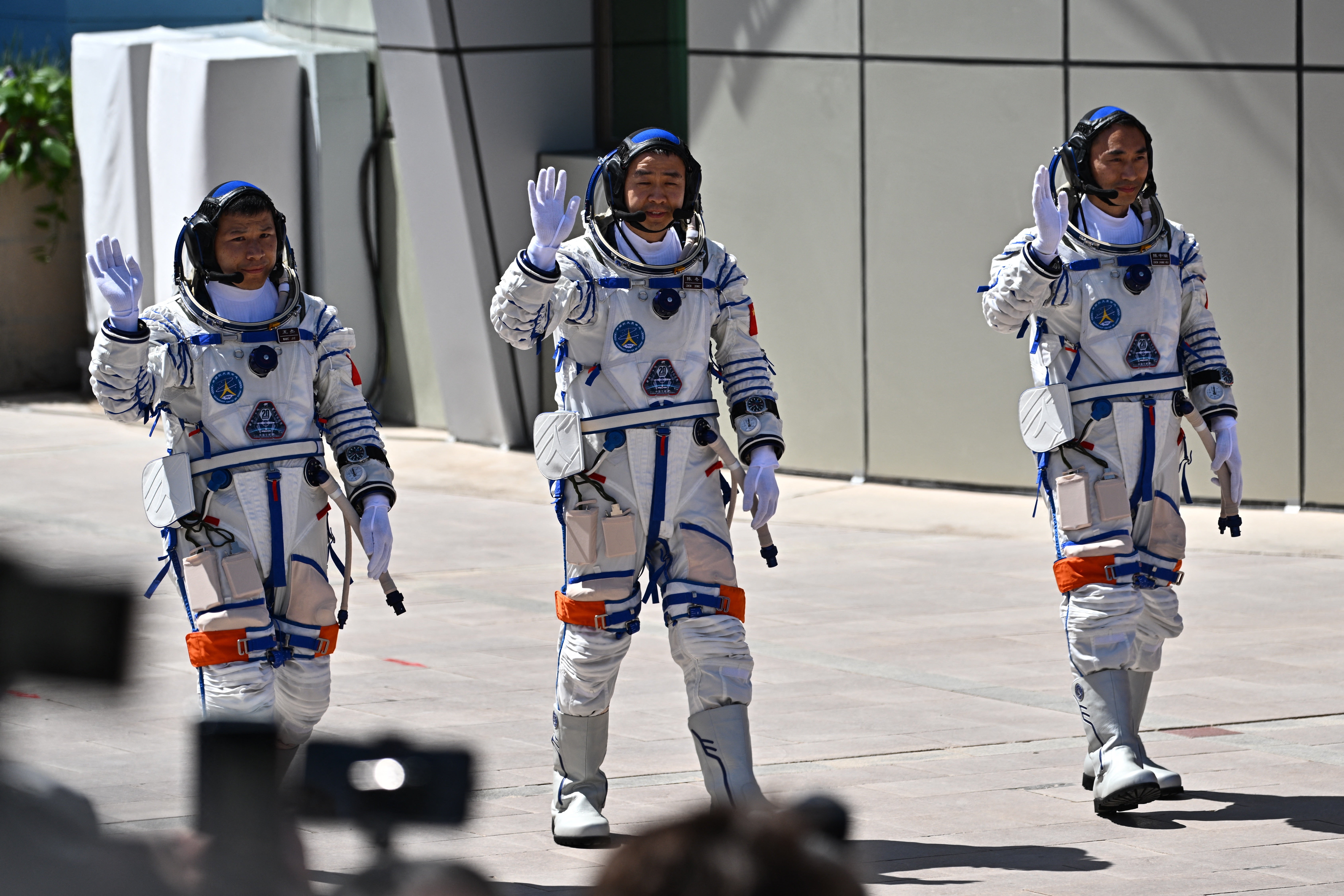 <p>Astronauts for China's Shenzhou-20 space mission (L-R) Wang Jie, Chen Dong, and Chen Zhongrui, wave during a departure ceremony</p>