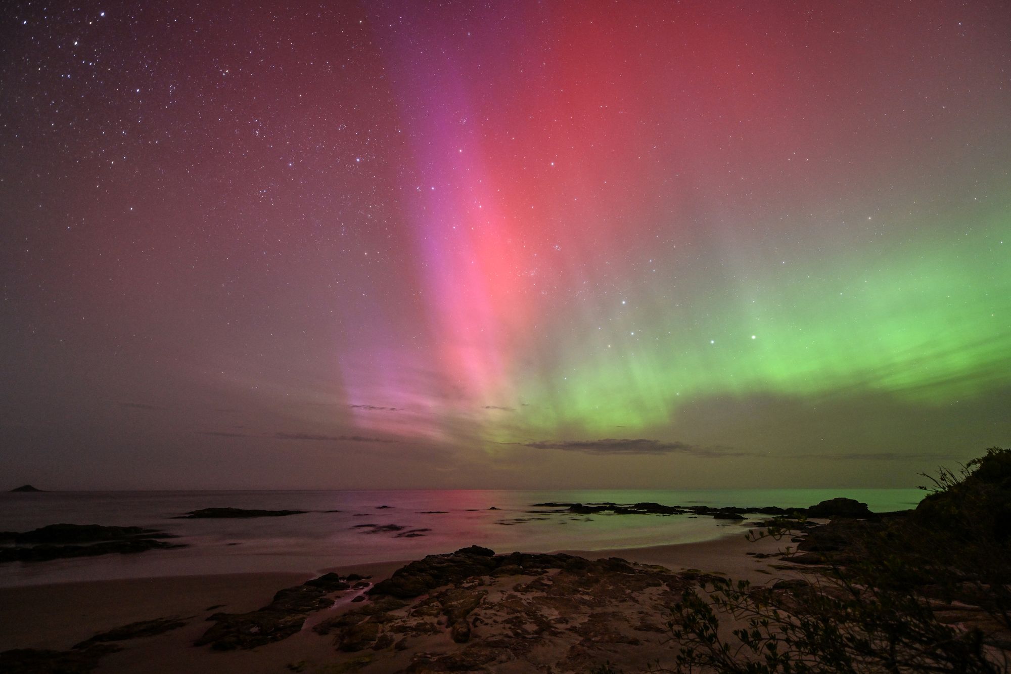 Aurora Australis, also known as the Southern Lights, glows on the horizon over the waters of Brighton Beach in Dunedin on November 13, 2025