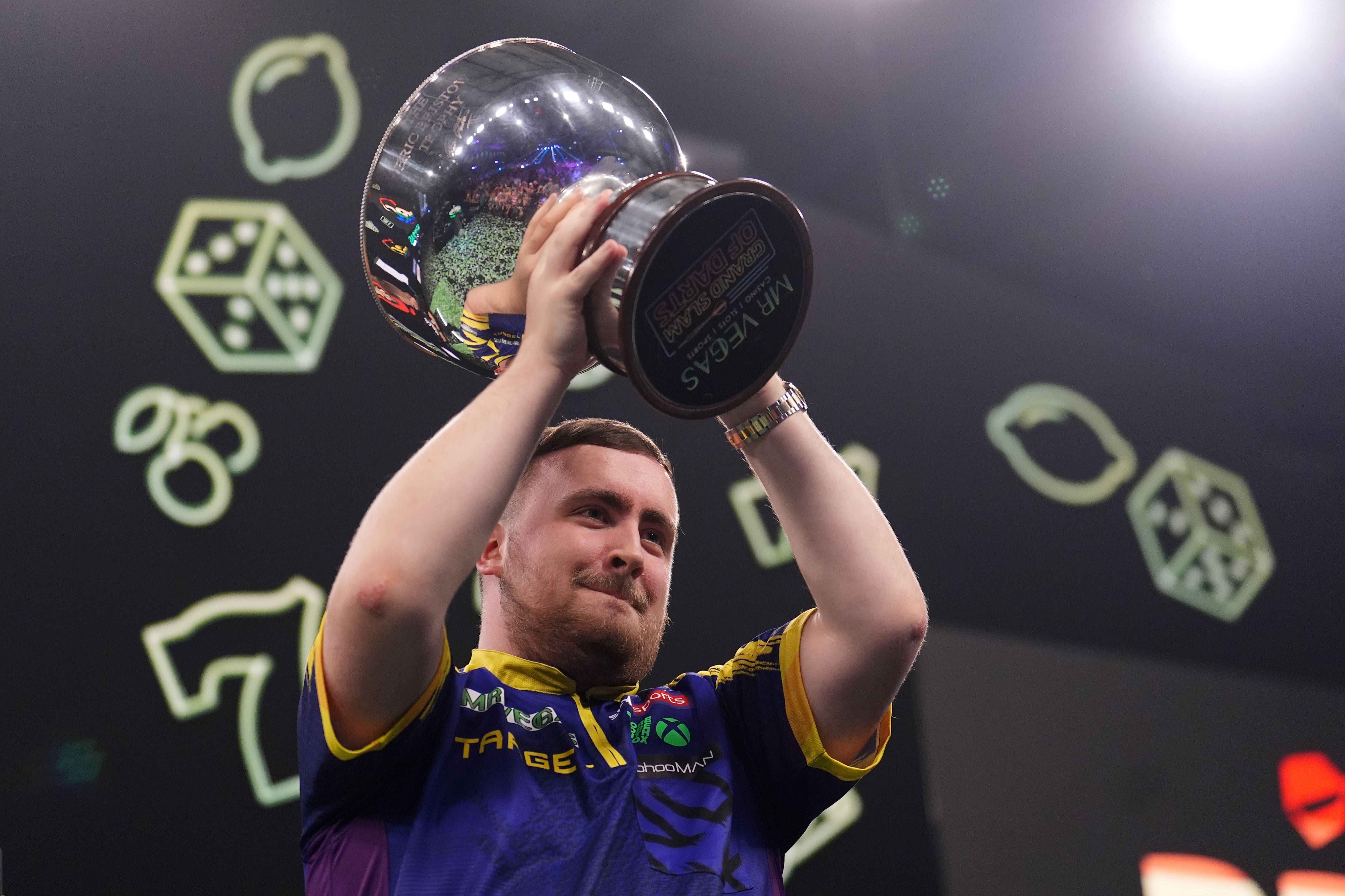 Luke Littler lifts the trophy after winning the Grand Slam of Darts final (Martin Rickett/PA)