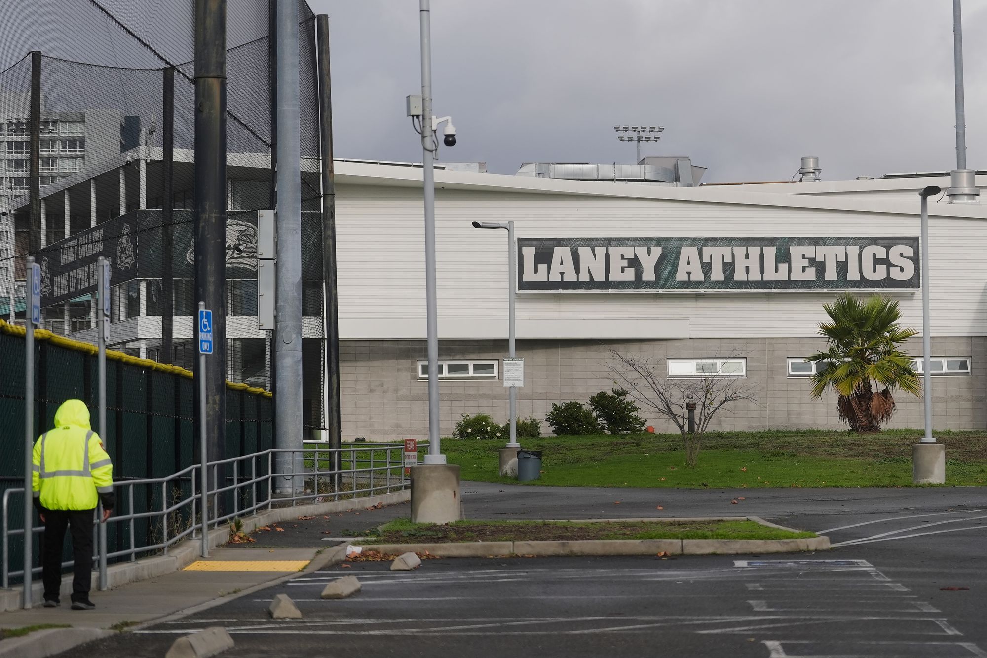 Um guarda patrulha o lado de fora das instalações de atletismo do Laney College, onde John Beam foi baleado e morto.