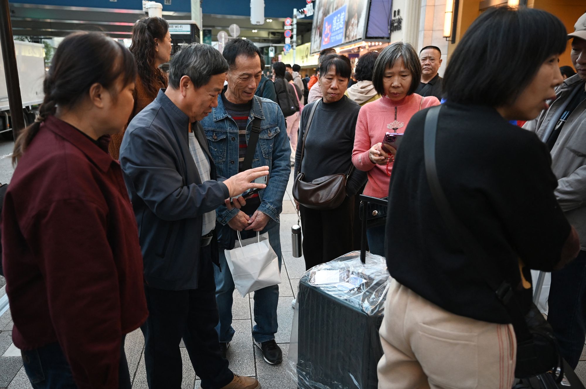 Chinese tourists look at items bought from a popular store in Tokyo on 17 November 2025