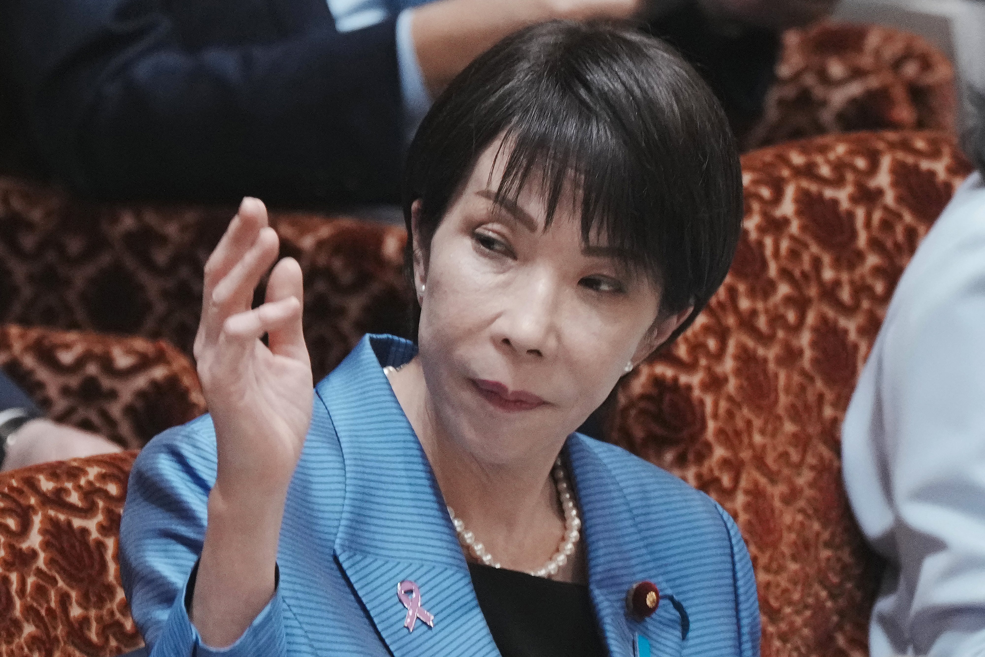 Sanae Takaichi raises her hand to answer a question during a session of the House of Councillors Budget Committee at the National Diet in Tokyo