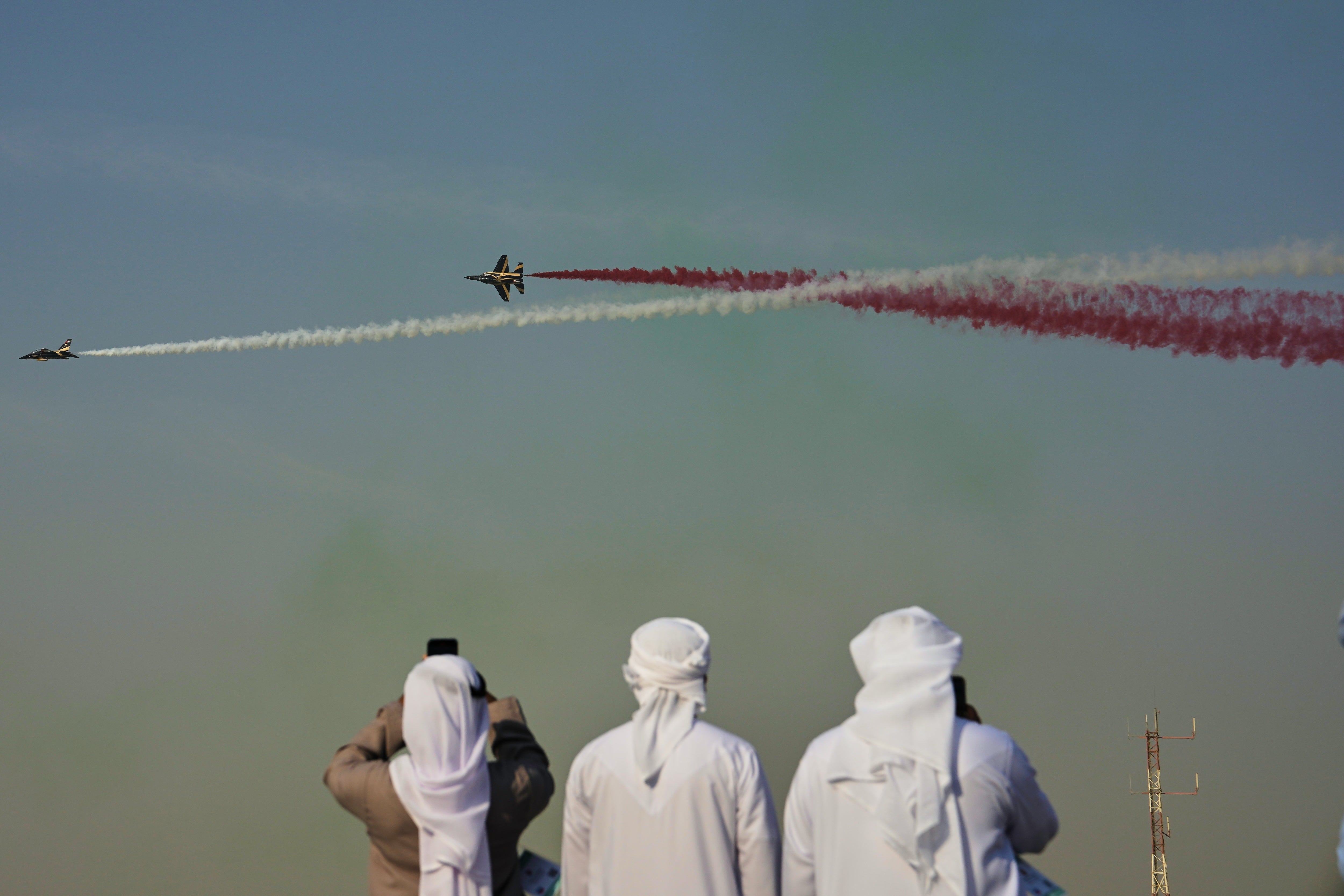 Emirati men take photos of Fursan Al Emarat, the aerobatics demonstration team of the United Arab Emirates Air Force during the Dubai Air Show in Dubai, United Arab Emirates, Tuesday, Nov. 18, 2025. (AP Photo/Fatima Shbair)