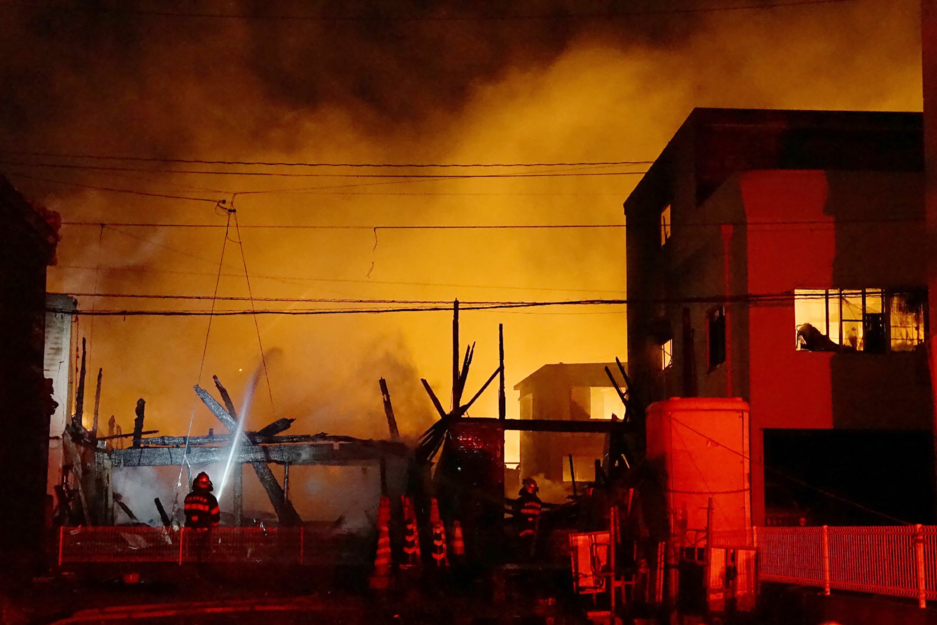 Firefighters work at the scene of a major blaze in Saganoseki, Oita city, late on 18 November 2025