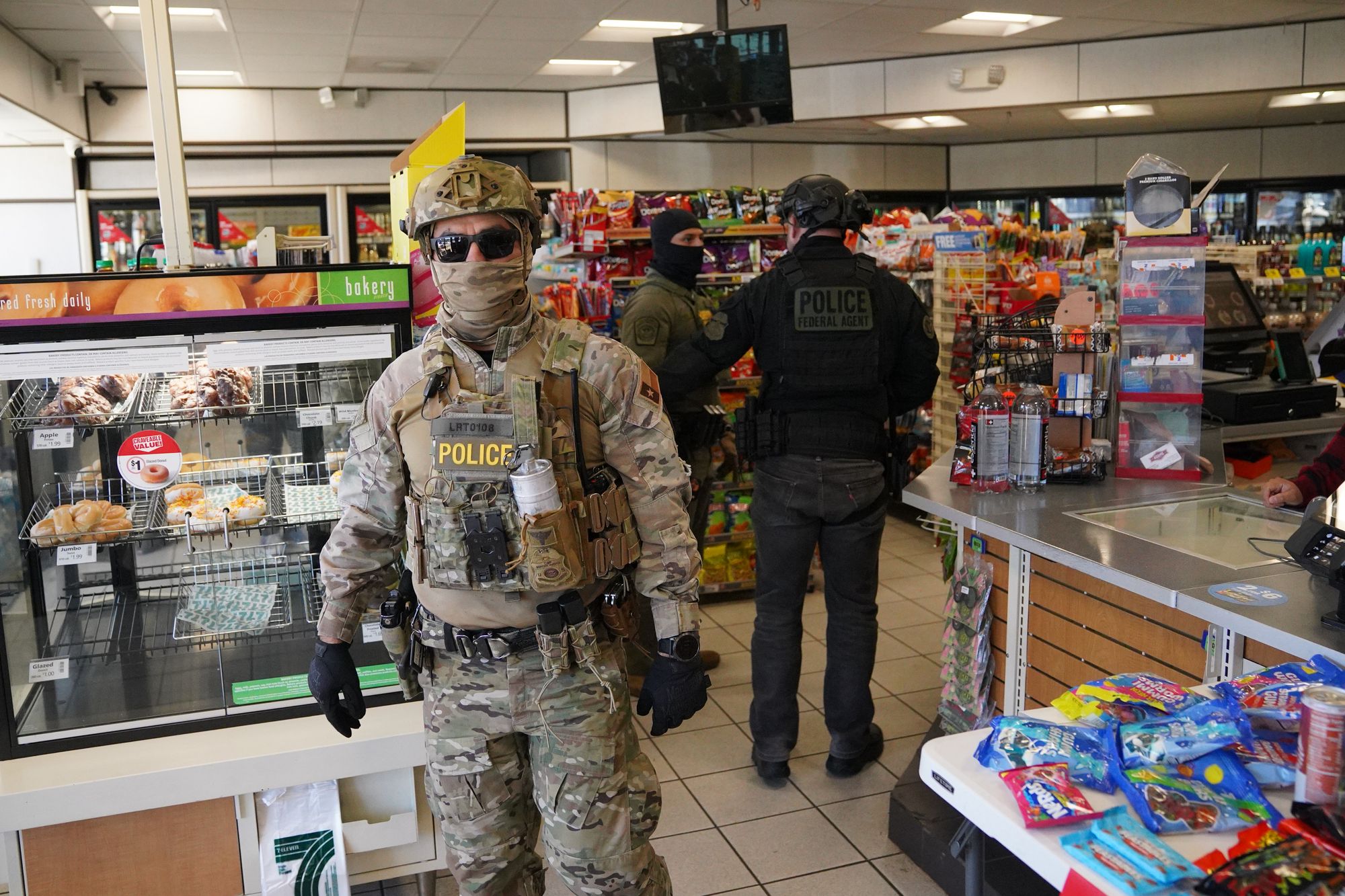 Federal agents walk through a store in Charlotte on Monday as local and federal officials insist they are not needed in the state