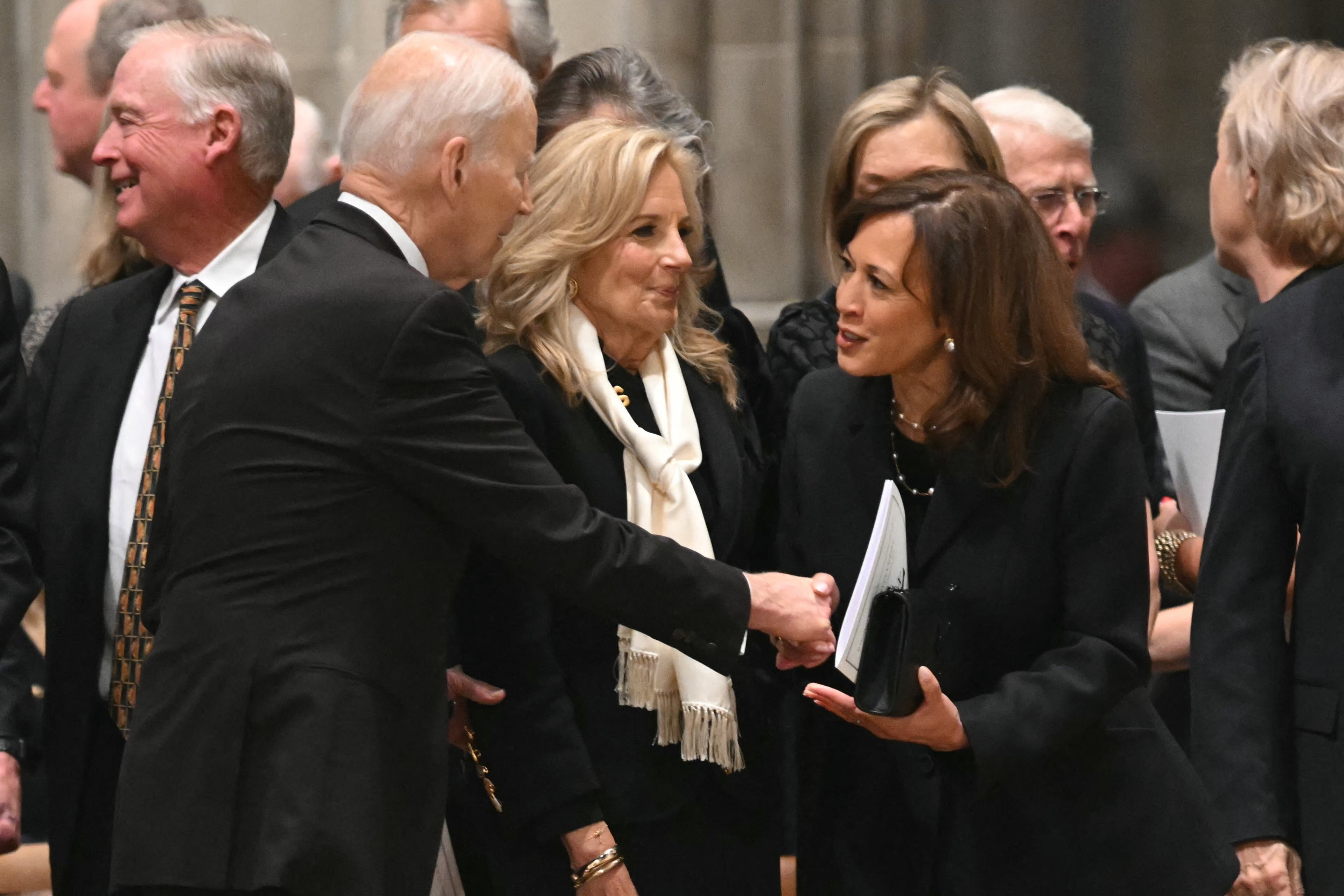 Former president Joe Biden shakes hands with his vice president – and successor as 2024 Democratic presidential nominee – Kamala Harris, as Jill Biden looks on