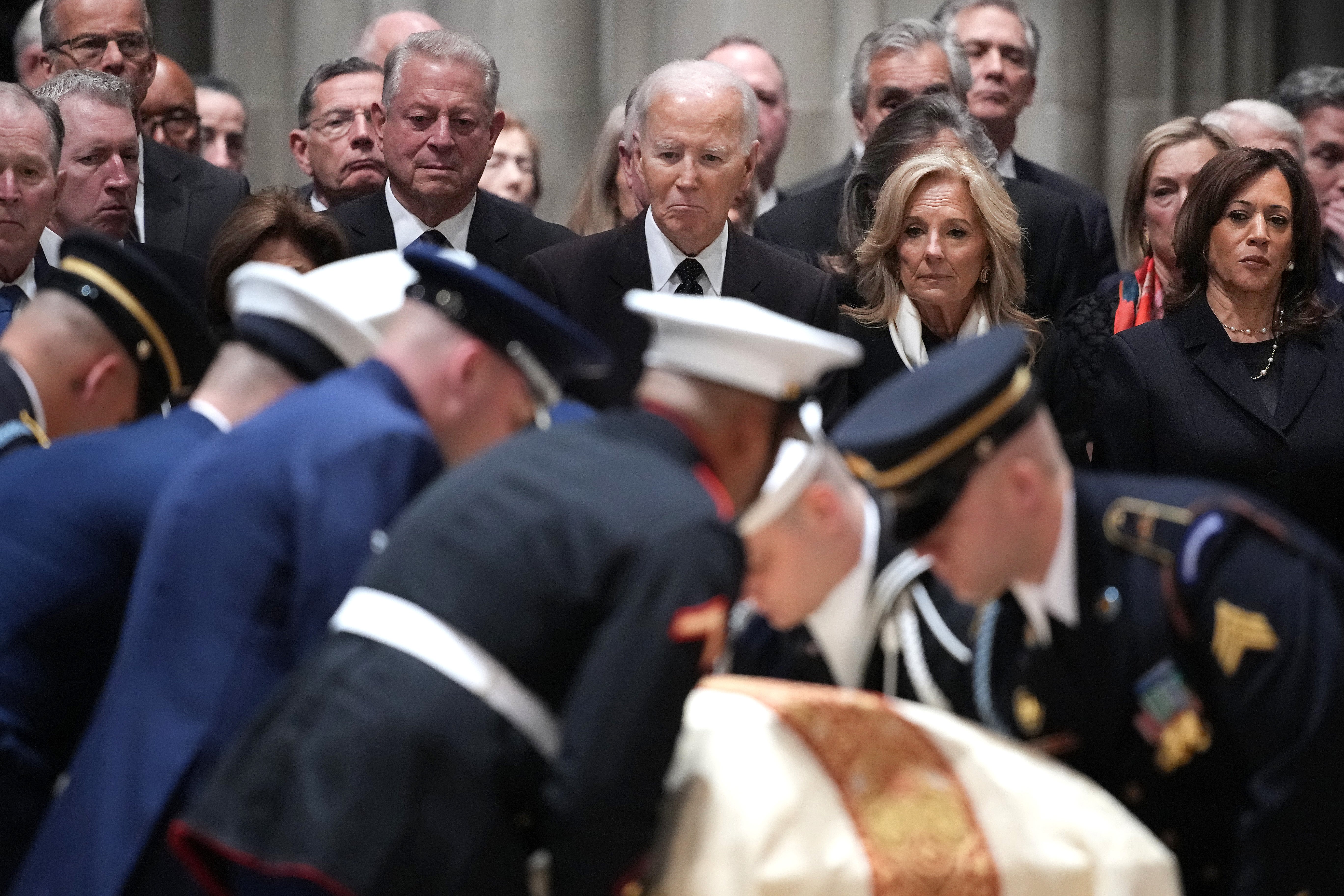 Former U.S. Vice President Al Gore, former President Joe Biden, former first lady Jill Biden, and former Vice President Kamala Harris stand as U.S. military body bearers carry the casket containing the remains of former U.S. Vice President Dick Cheney during Cheney's funeral service at the National Cathedral on November 20, 2025 in Washington, DC